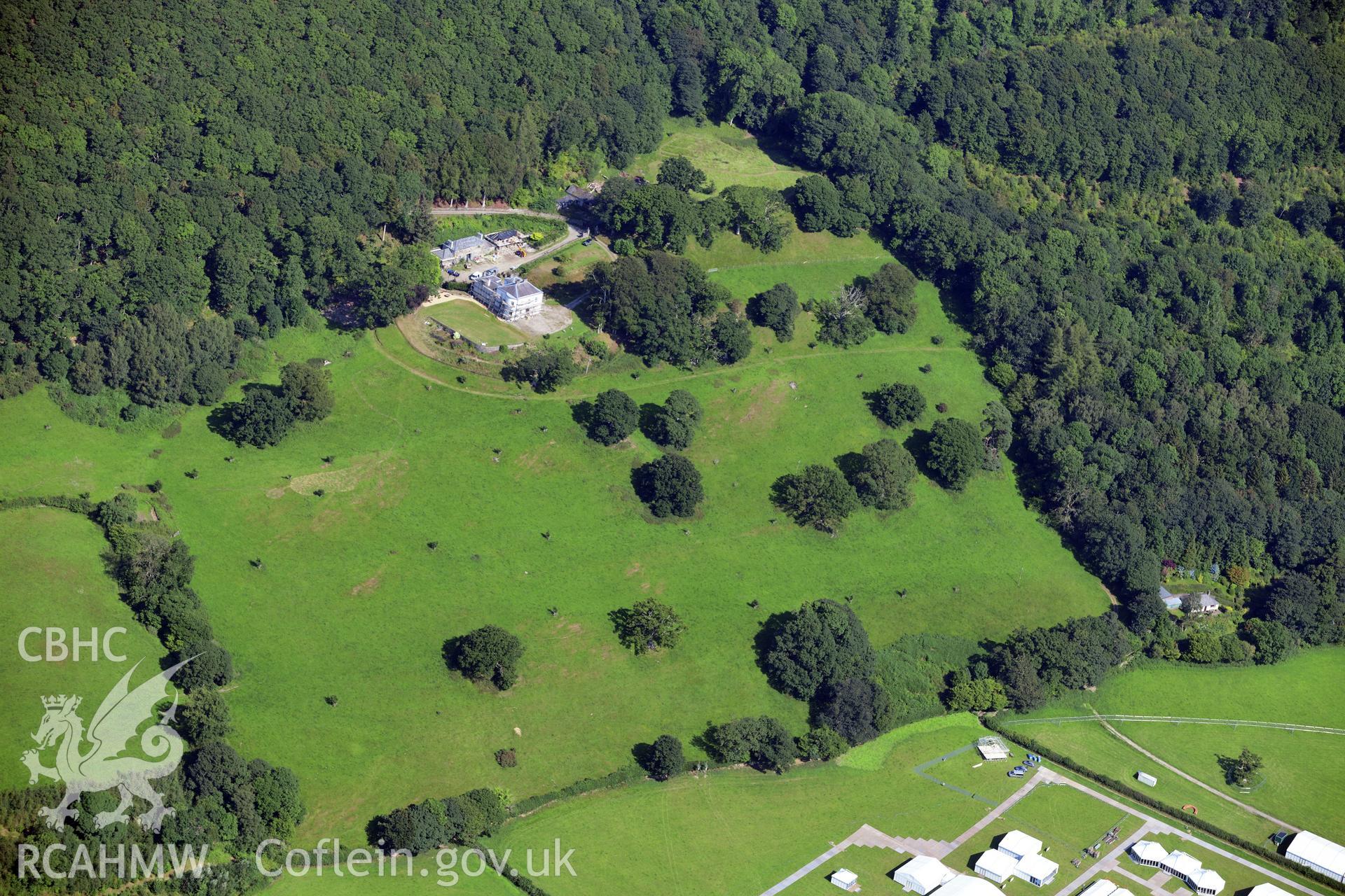 Hendre House and Garden, with the Eisteddfod site in the bottom right hand corner. Oblique aerial photograph taken during the Royal Commission?s programme of archaeological aerial reconnaissance by Toby Driver on 23rd July 2019.