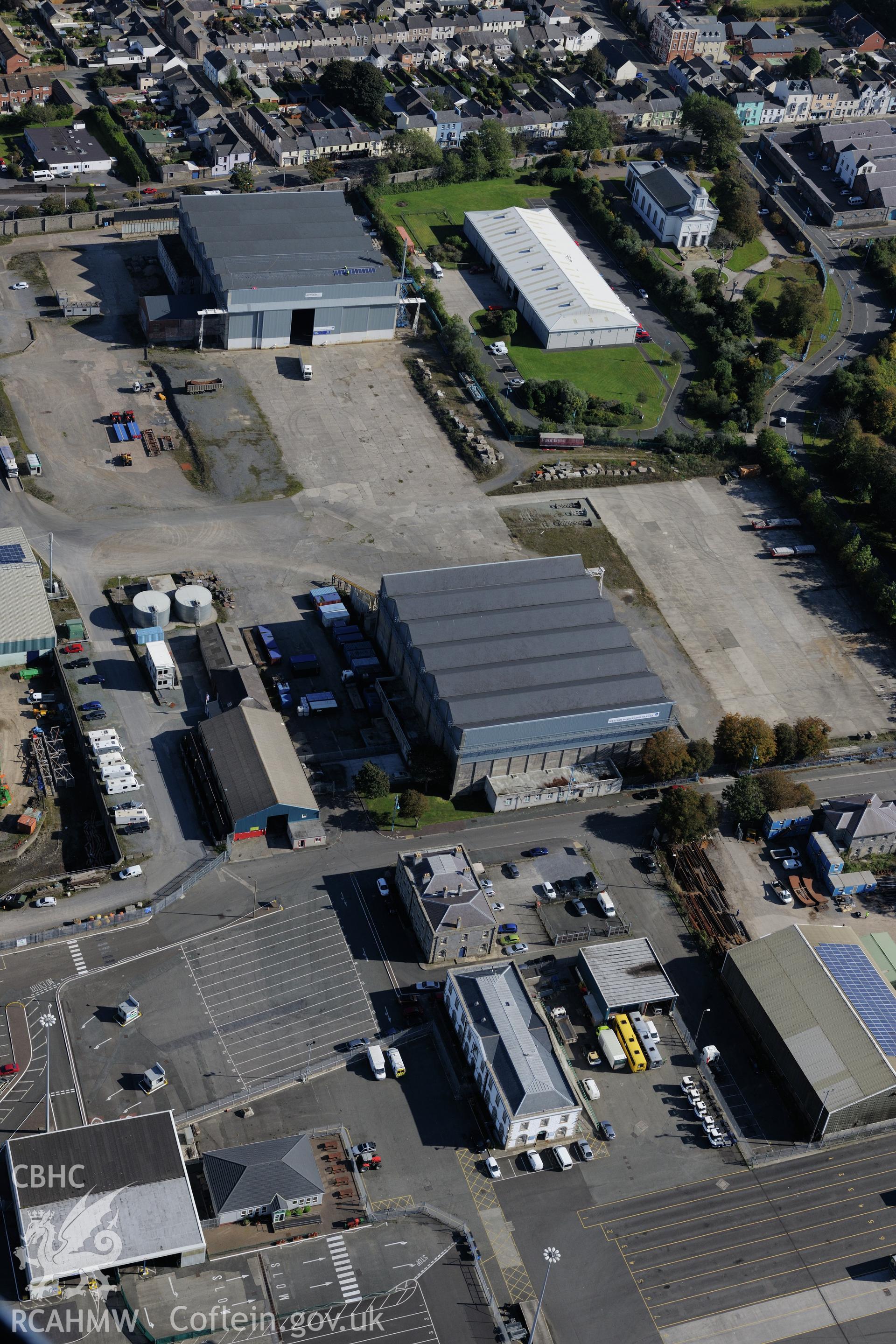 Pembroke Dockyard including the storehouse, motor museum, office block and the east and west hangars of the flying boat station. Oblique aerial photograph taken during the Royal Commission's programme of archaeological aerial reconnaissance by Toby Driver on 30th September 2015.