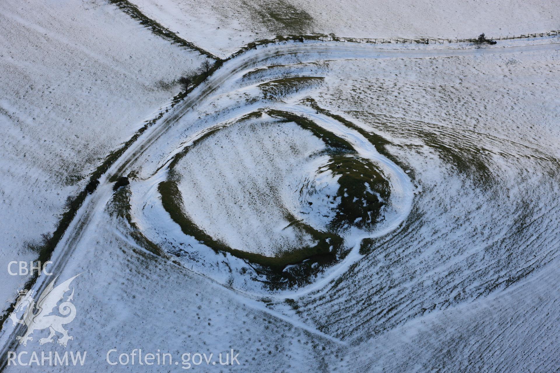 RCAHMW colour oblique photograph of Castell Crugerydd, motte and bailey under snow. Reproduced in Driver & Davis (2012) Historic Wales from the Air (RCAHMW), Figure 76, page 89. Taken by Toby Driver on 18/12/2011.