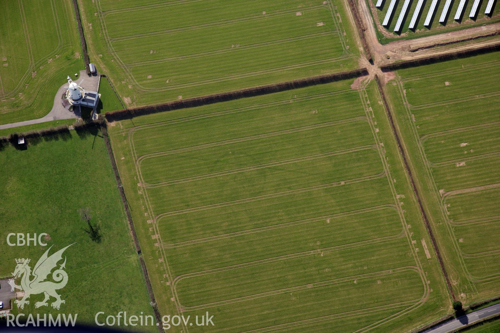 RCAHMW colour oblique photograph of Llancayo Farm Roman marching camp, and site of temple; cropmarks showing east side of camp and barrow cemetery. Taken by Toby Driver and Oliver Davies on 28/03/2012.