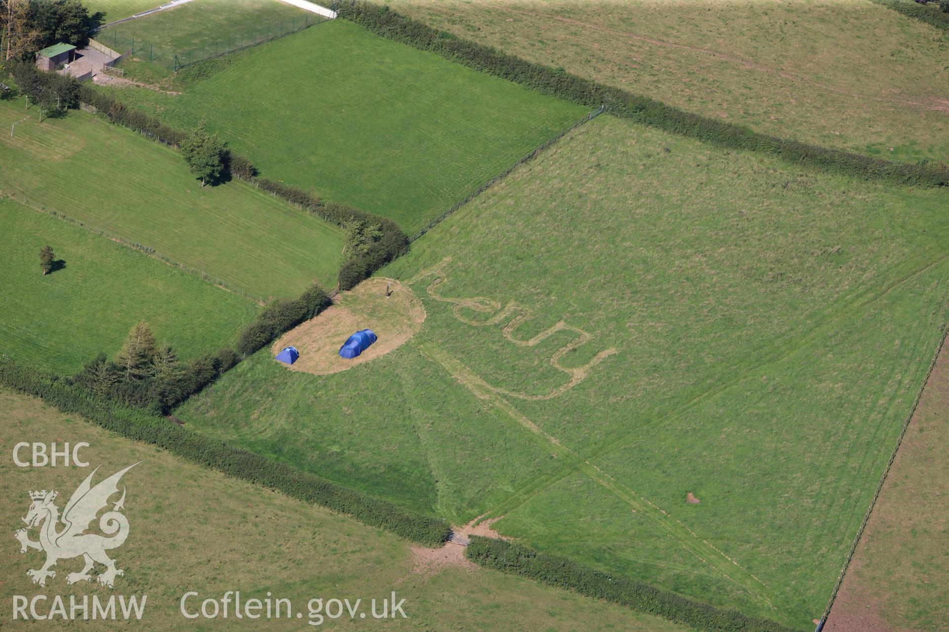 RCAHMW colour oblique photograph of Llanblethian; campsite with 'Harry' graffiti mown into grass. Taken by Toby Driver on 24/07/2012.