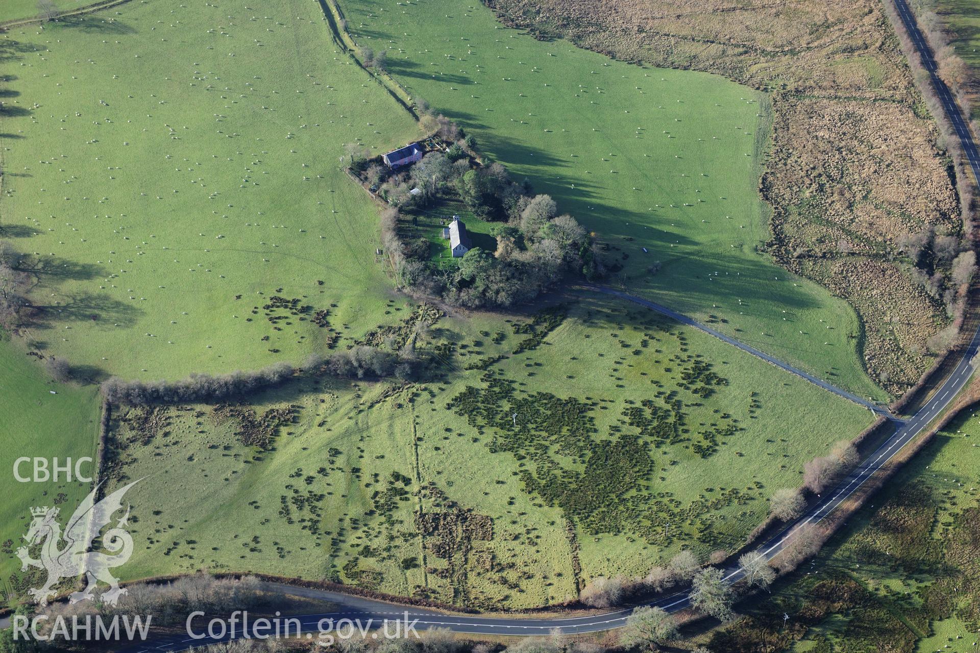 RCAHMW colour oblique photograph of Llanlleonfel Church, wide view showing earthworks in vicinity of church. Taken by Toby Driver on 23/11/2012.