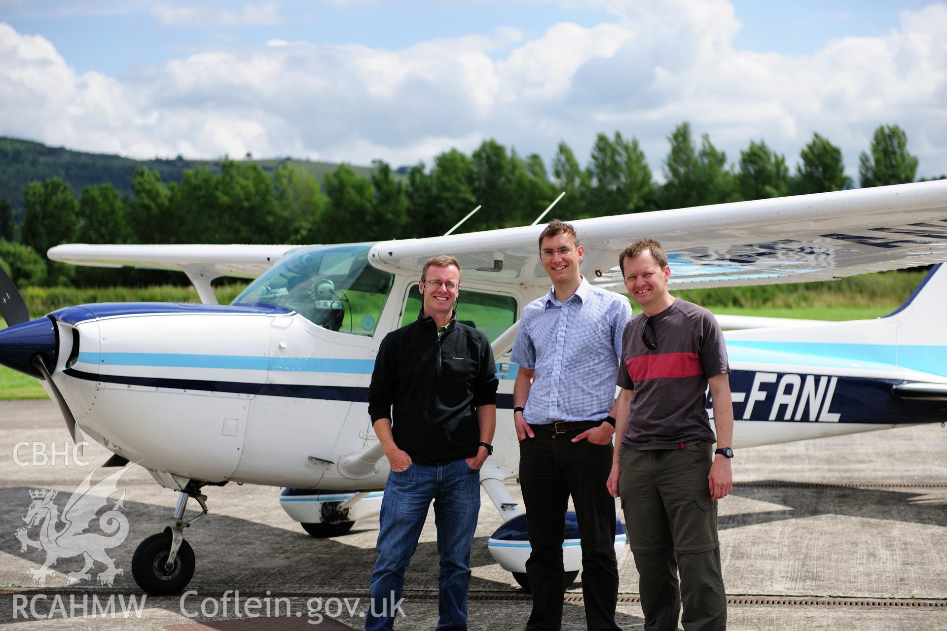 RCAHMW colour oblique photograph of Welshpool Airport. Left to right; Toby Driver (RCAHMW), Andy Wigley (Shropshire CC) and Neil Rimmington (Herefordshire CC) following archaeological aerial photography. Taken by Toby Driver on 27/07/2012.