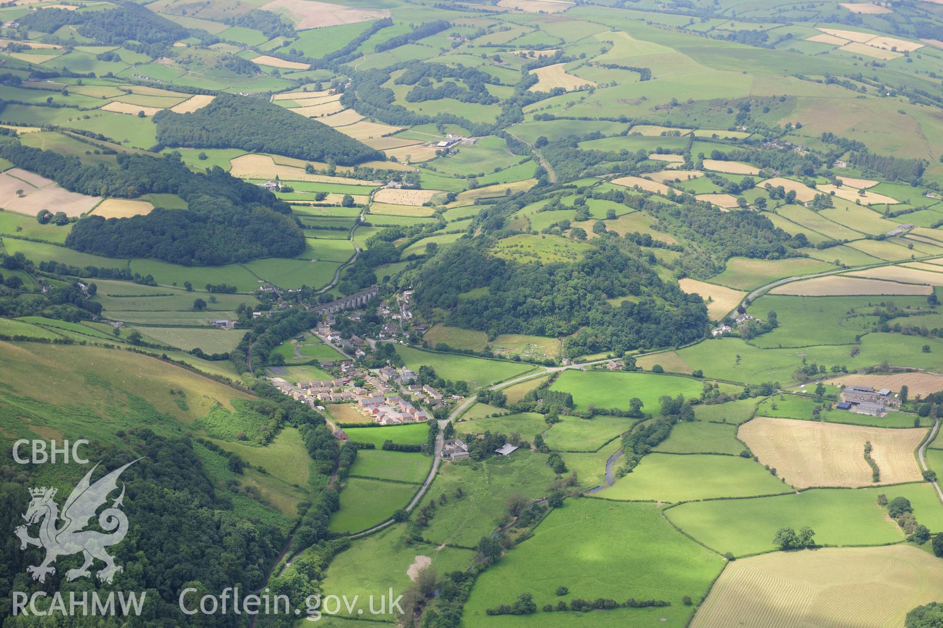 RCAHMW colour oblique photograph of Knucklas Castle, landscape view with village. Taken by Toby Driver on 27/07/2012.