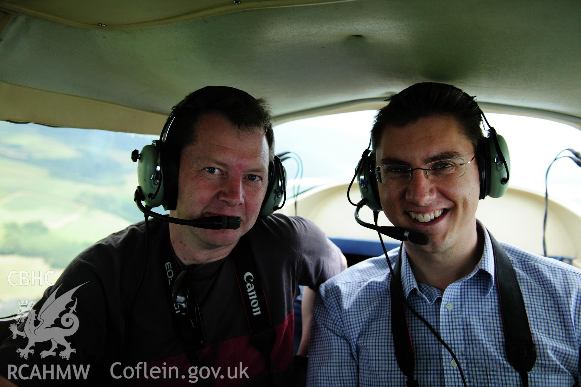 RCAHMW colour oblique photograph of Neil Rimmington (Herefordshire CC) and Andy Wigley (Shropshire CC) undertaking archaeological aerial photography from Welshpool Airport with RCAHMW. Taken by Toby Driver on 27/07/2012.