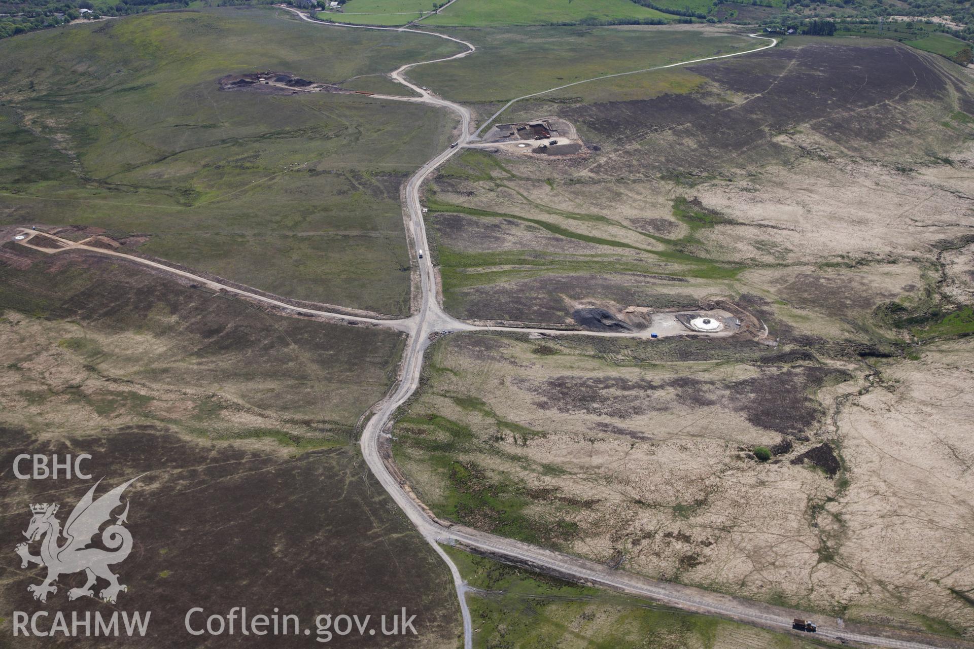 RCAHMW colour oblique photograph of Bancbryn farmstead, and Mynydd y Betws windfarm, under construction.View looking south. Taken by Toby Driver on 22/05/2012.