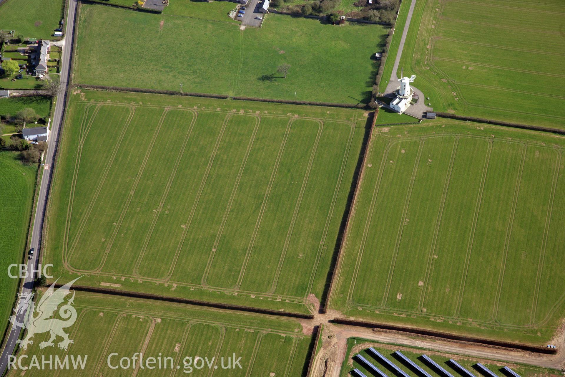 RCAHMW colour oblique photograph of Llancayo Farm Roman marching camp, and site of temple; cropmarks showing east side of camp and barrow cemetery. Taken by Toby Driver and Oliver Davies on 28/03/2012.