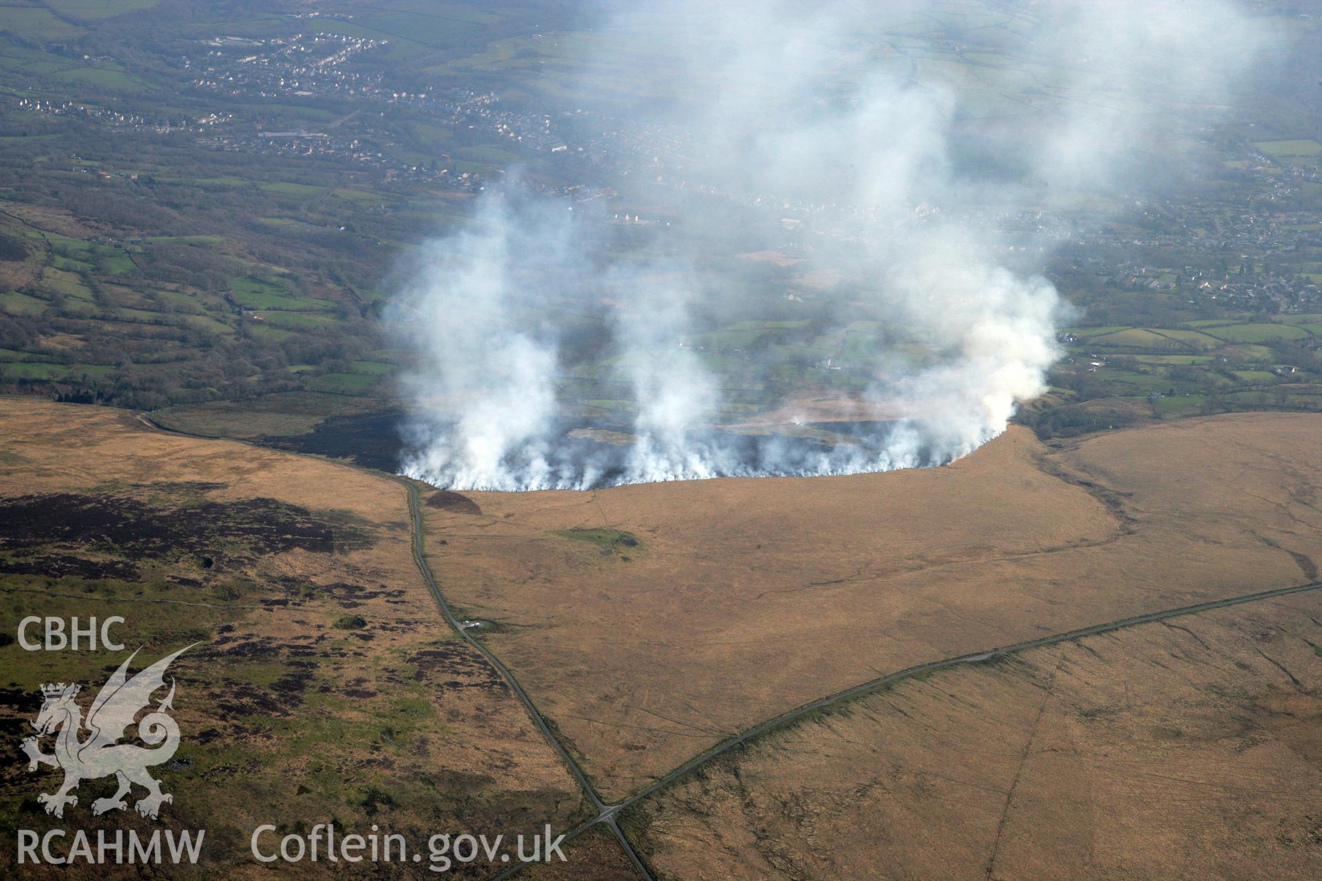 RCAHMW colour oblique photograph of Banc Crucorfod round cairn, with grass fire, view south towards Glanaman. Taken by Toby Driver and Oliver Davies on 28/03/2012.
