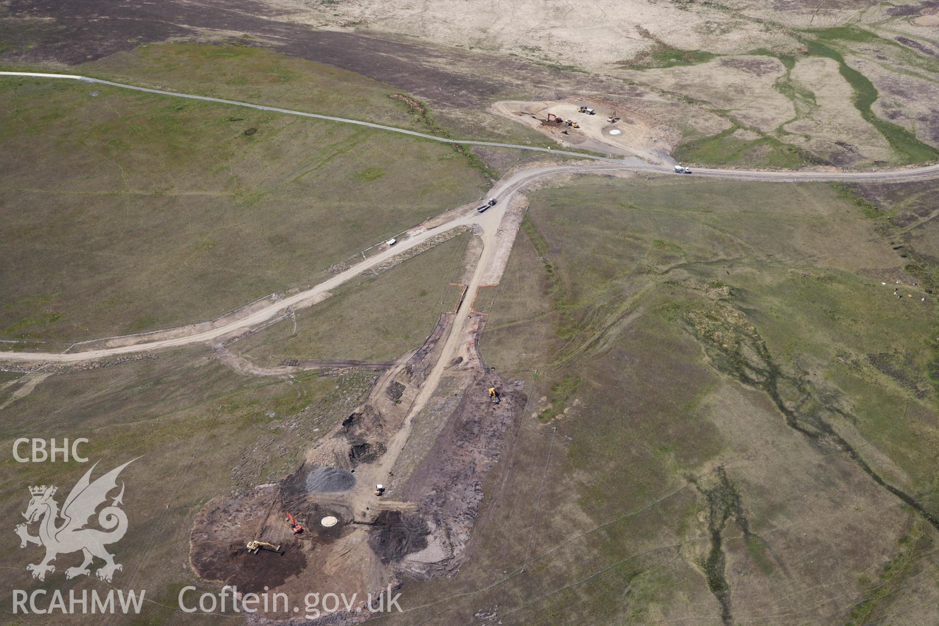 RCAHMW colour oblique photograph of Banc y Bryn cairn cemetery, and Mynydd y Betws windfarm, under construction.View looking west. Taken by Toby Driver on 22/05/2012.