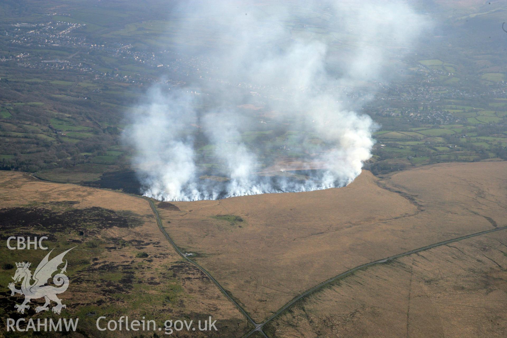 RCAHMW colour oblique photograph of Banc Crucorfod round cairn, with grass fire, view south towards Glanaman. Taken by Toby Driver and Oliver Davies on 28/03/2012.