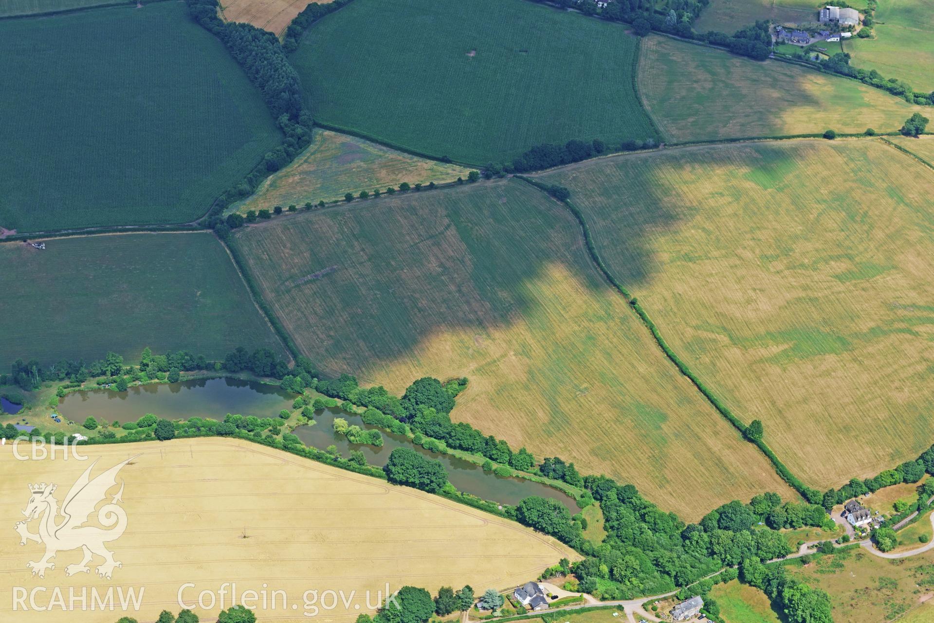 Royal Commission aerial photography of Trellech Grange, showing cropmarks northeast of Grange Spring Lakes at SO 496018, taken on 19th July 2018 during the 2018 drought.