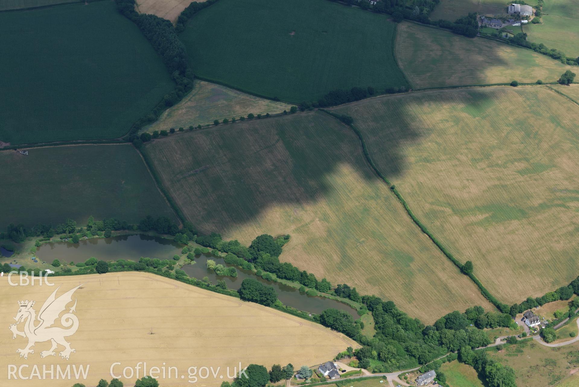 Royal Commission aerial photography of Trellech Grange, showing cropmarks northeast of Grange Spring Lakes at SO 496018, taken on 19th July 2018 during the 2018 drought.