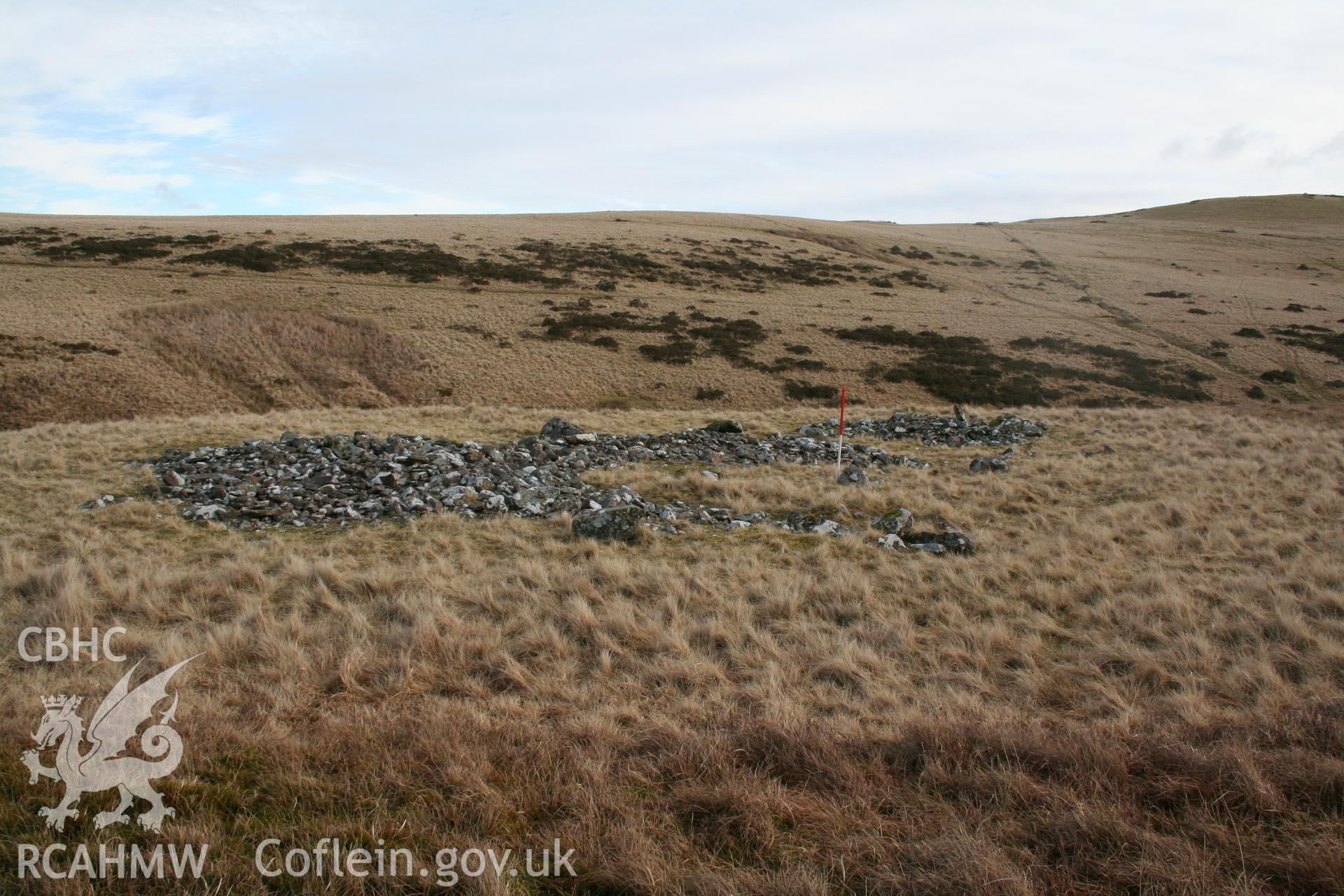 Spread remains of cairn seen from the west; 1m scale.