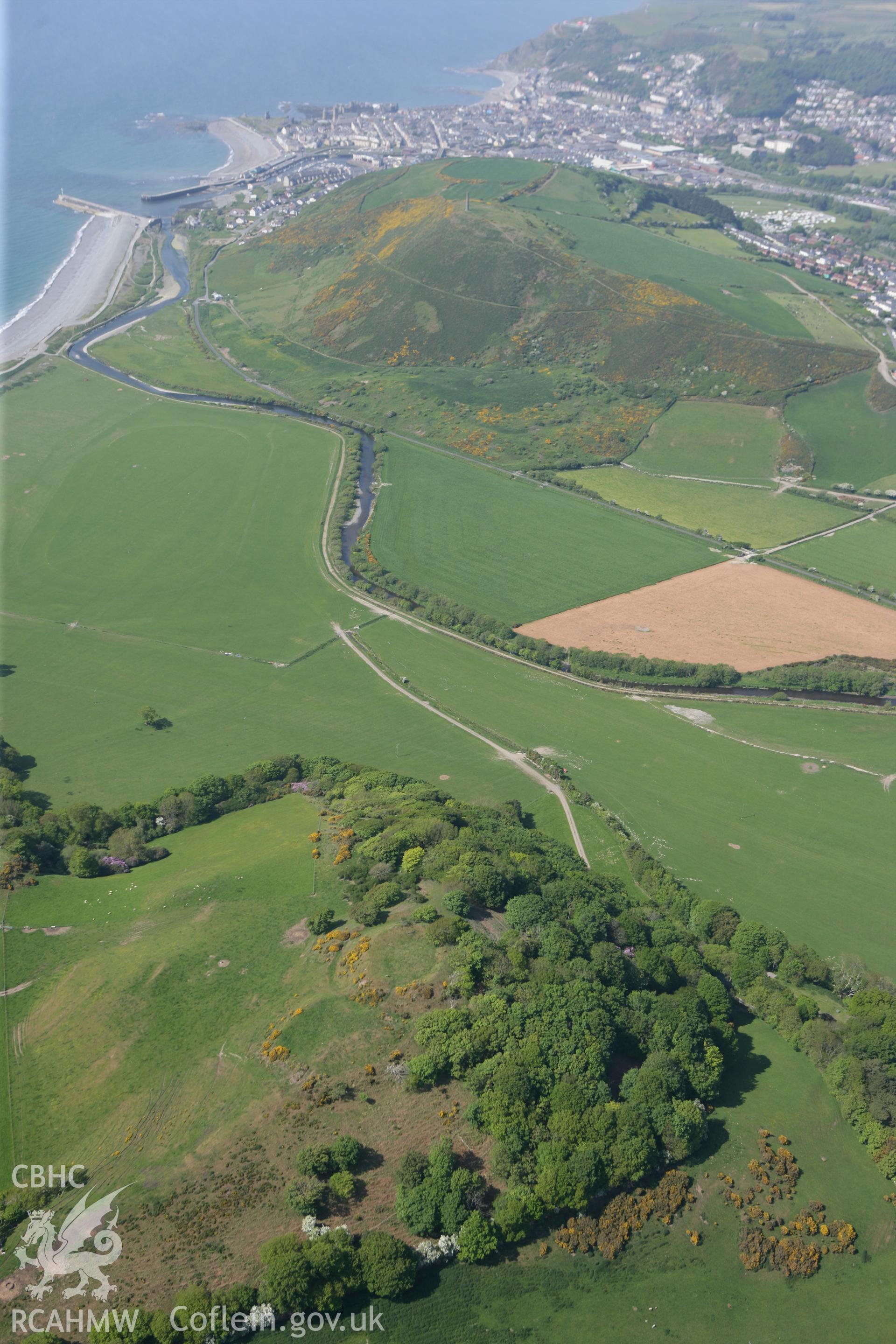 RCAHMW colour oblique photograph of Tanycastell motte, wide landscape view. Taken by Toby Driver on 25/05/2010.