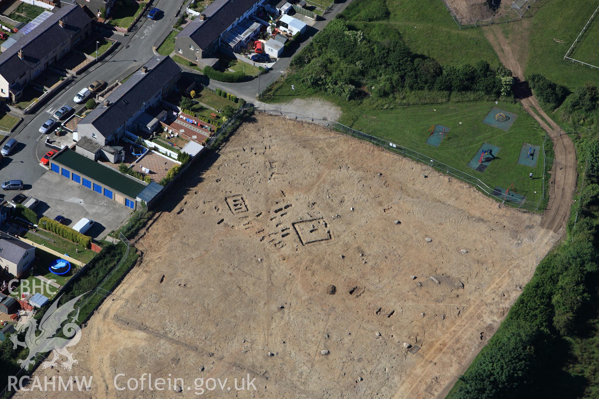 RCAHMW colour oblique photograph of Tyddyn Pandy Square Barrow Cemetery under excavation by Gwynedd Archaeological Trust. Taken by Toby Driver on 16/06/2010.