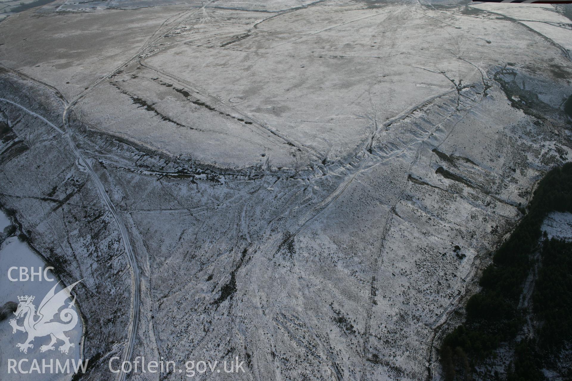 RCAHMW colour oblique photograph of ring cairn on Tor Clawdd from the north, with quarries and trackways. Taken by Toby Driver on 01/12/2010.