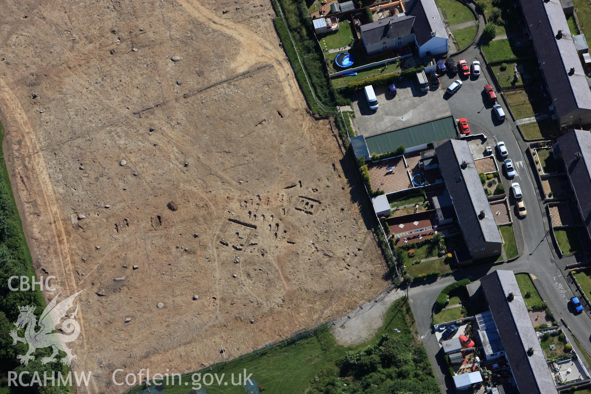 RCAHMW colour oblique photograph of Tyddyn Pandy Square Barrow Cemetery under excavation by Gwynedd Archaeological Trust. Taken by Toby Driver on 16/06/2010.