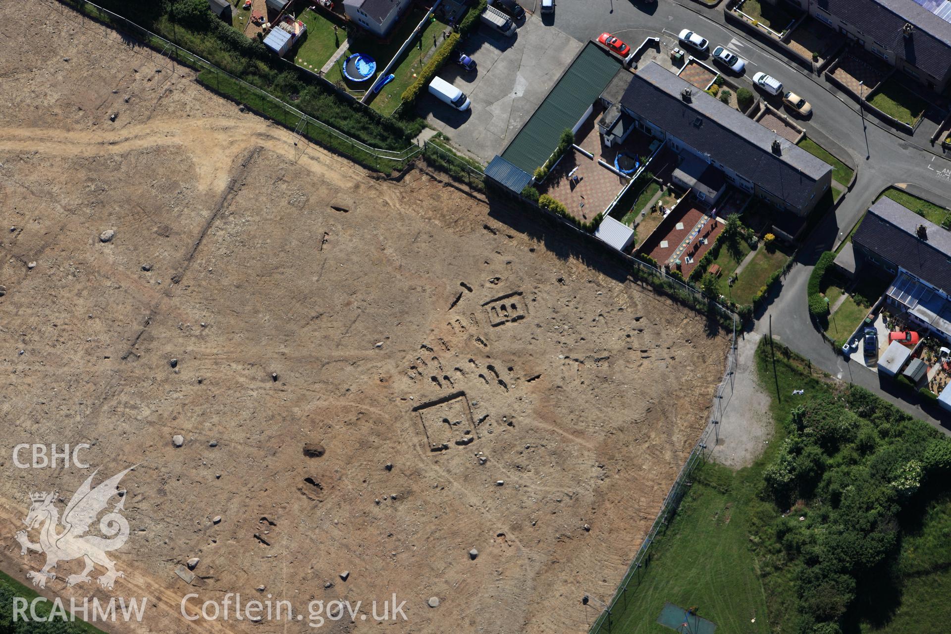 RCAHMW colour oblique photograph of Tyddyn Pandy Square Barrow Cemetery under excavation by Gwynedd Archaeological Trust. Taken by Toby Driver on 16/06/2010.