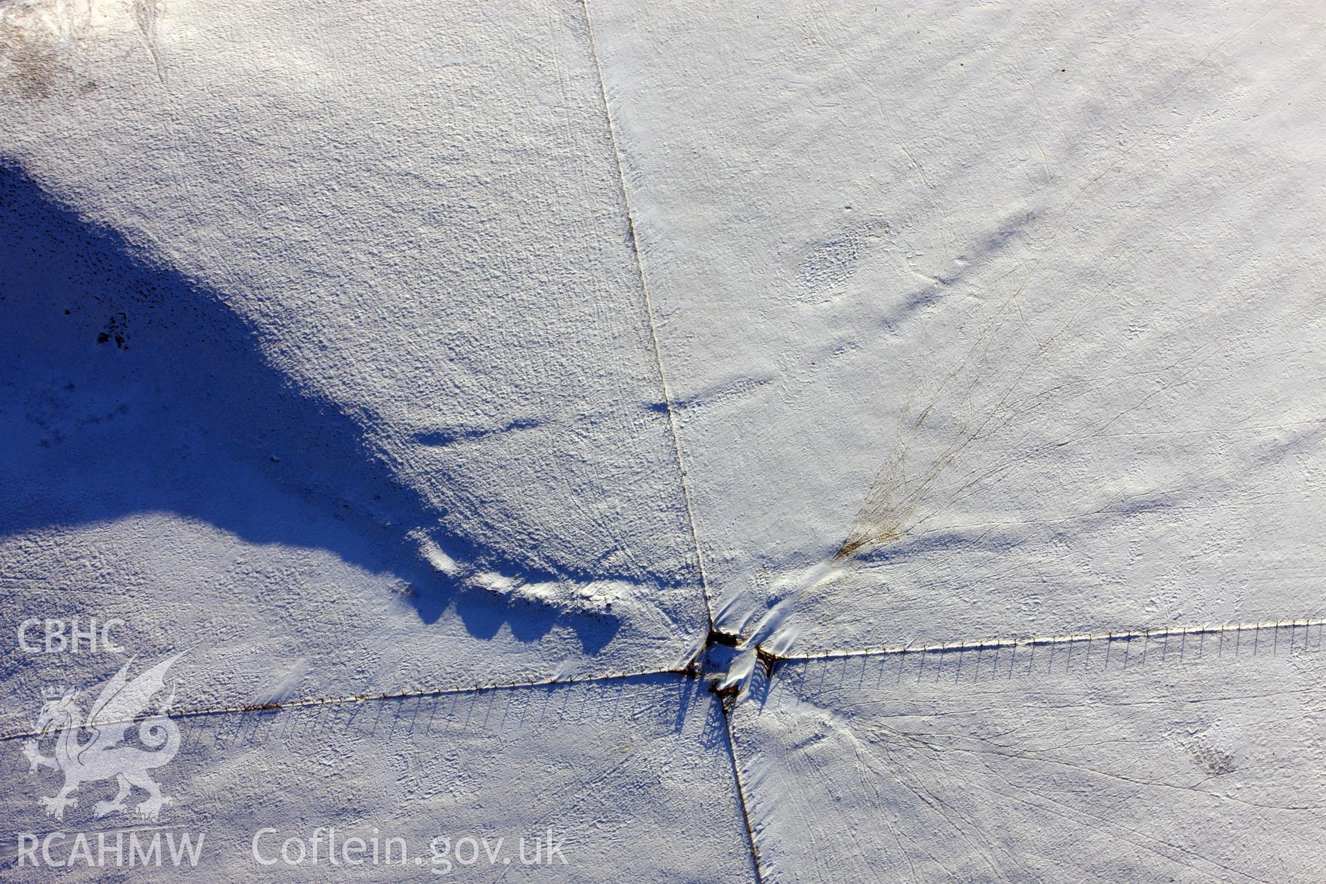 RCAHMW colour oblique aerial photograph of Banc Du Neolithic causewayed enclosure under snow, by Toby Driver, 01/12/2010.