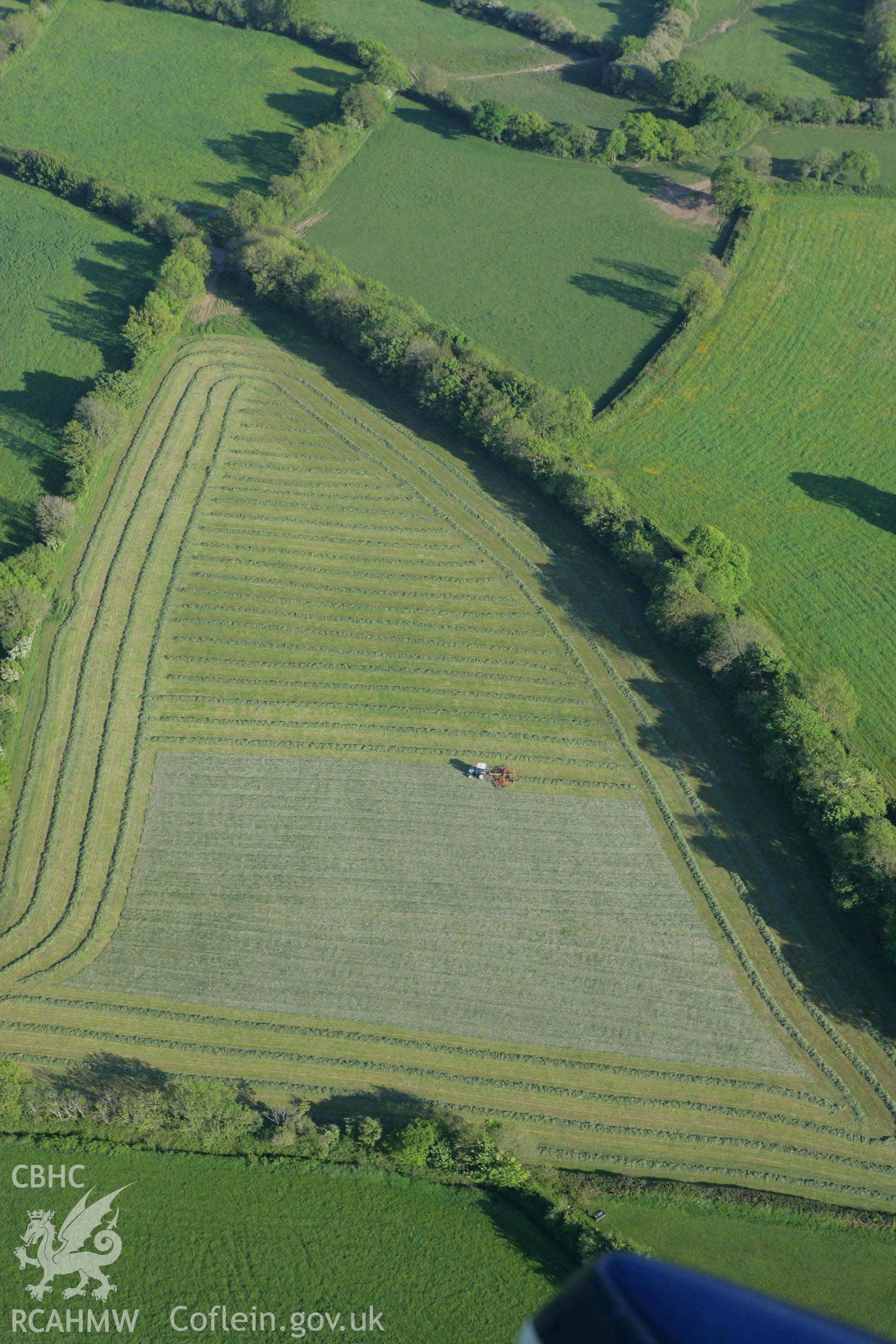 RCAHMW colour oblique photograph of harvesting in field adjacent to Goschen Chapel, Llawhaden. Taken by Toby Driver on 24/05/2010.