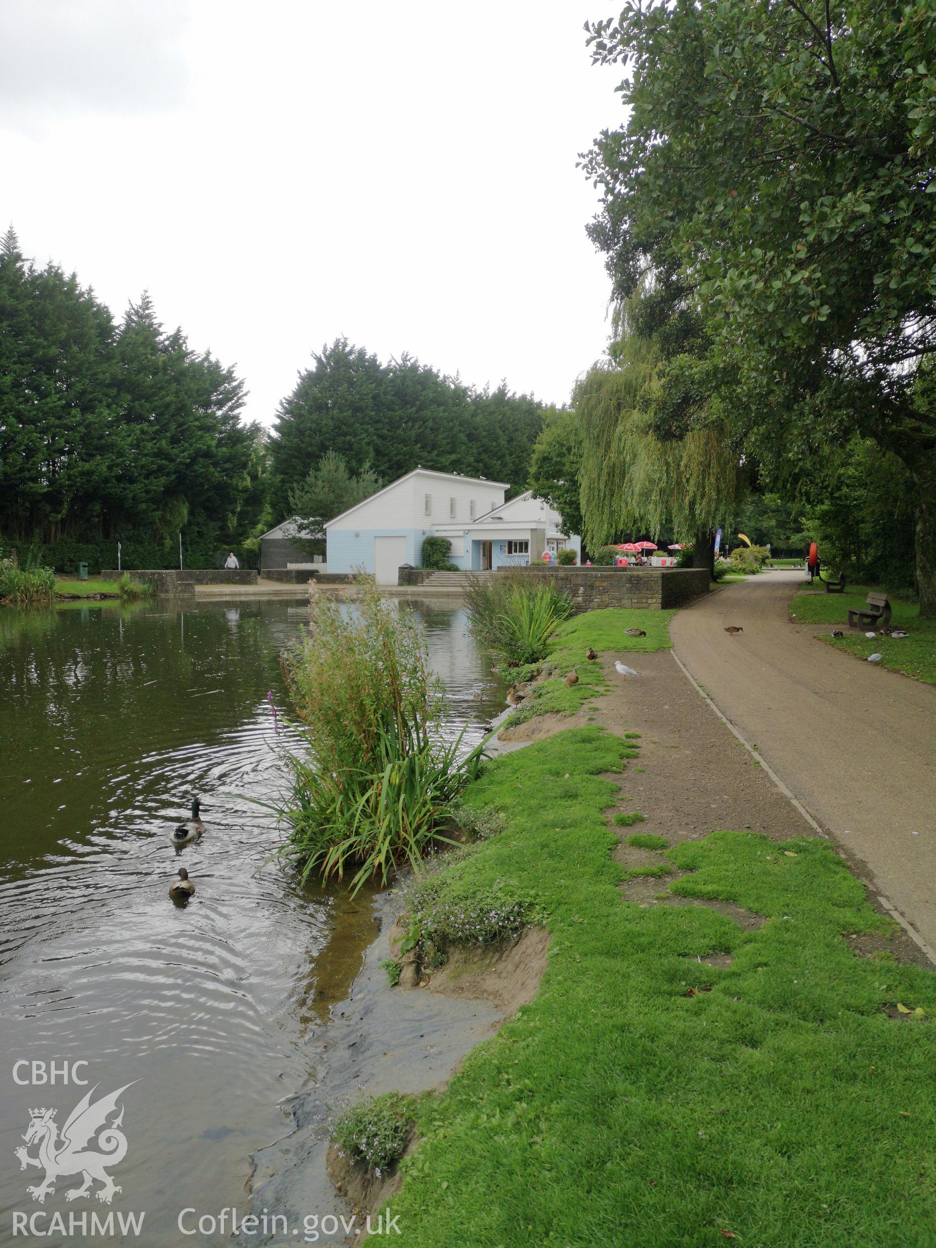 A pond in the foreground and buildings in the background at Cwmbran Park, photographed by Susan Fielding of RCAHMW on 12 September 2019.