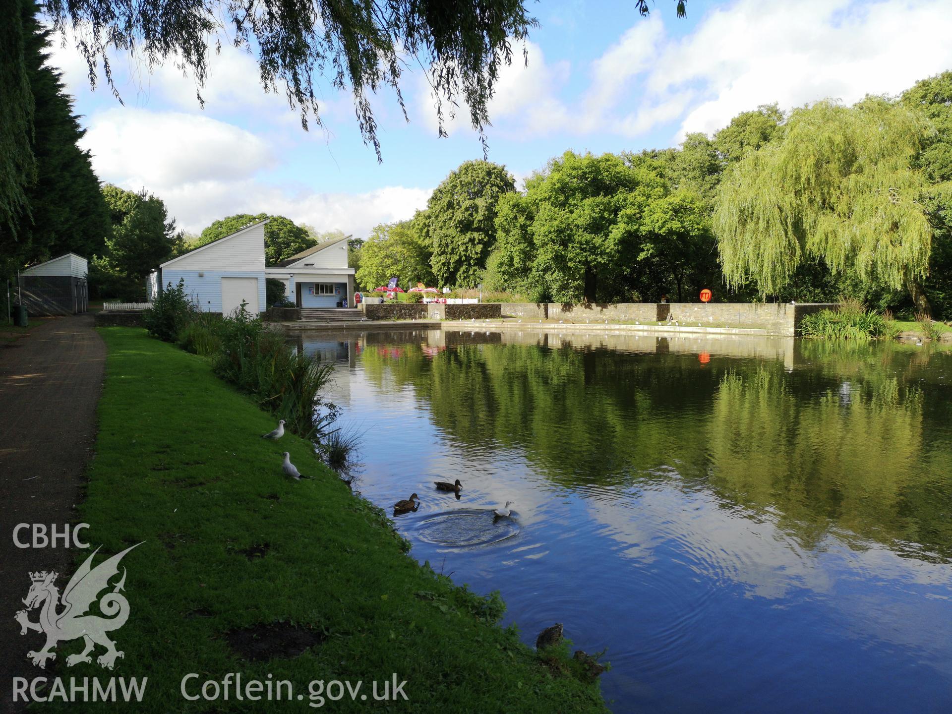 Body of water surrounded by trees, with building and ducks at Cwmbran Park, photographed by Susan Fielding of RCAHMW on 12 September 2019.