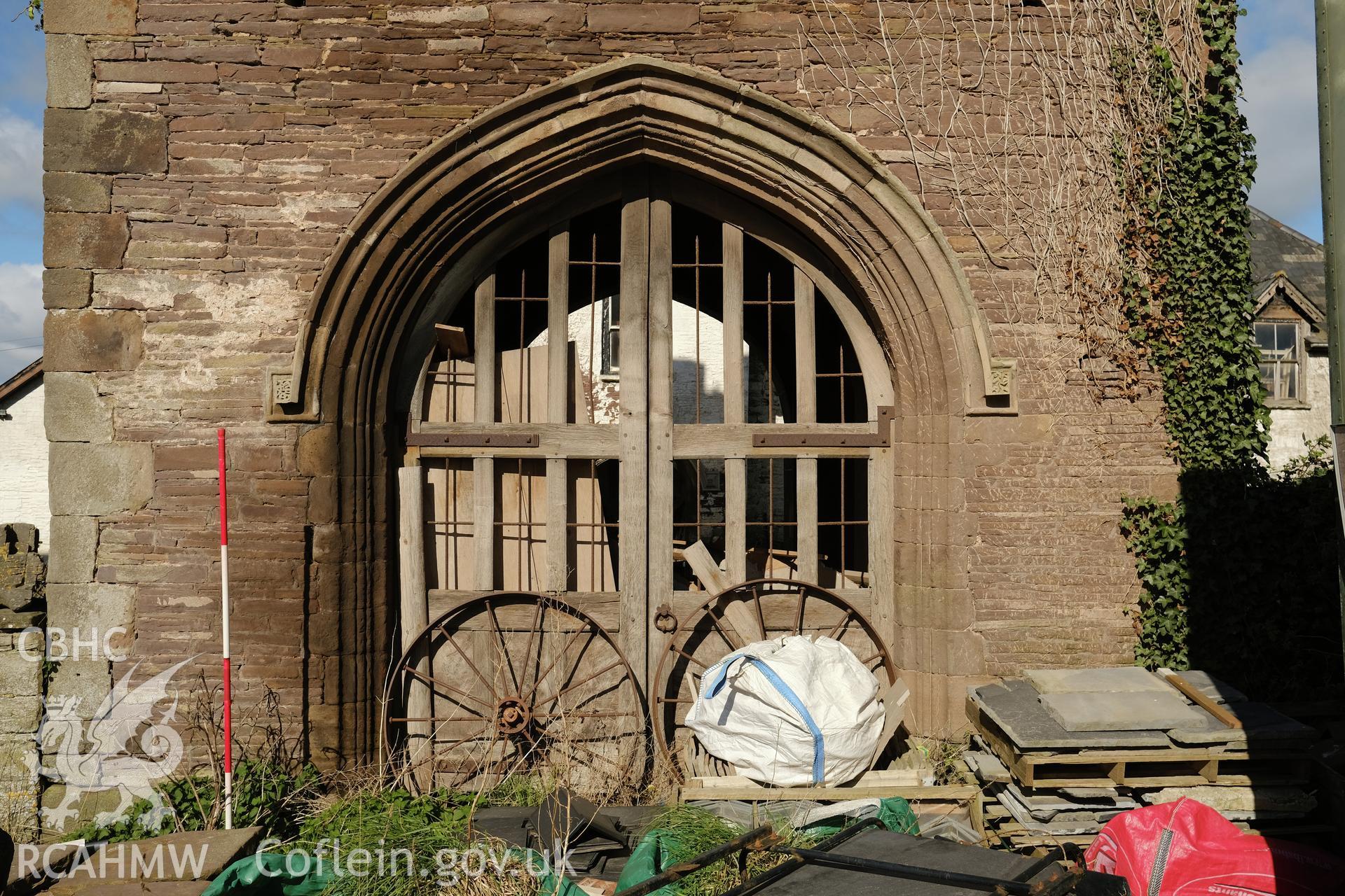 Colour photograph showing Great Porthmel Gatehouse - arch and gate in SE front. Produced as part of Historic Building Recording for Great Porthamel Gatehouse, carried out by Richard Hayman, April 2021.