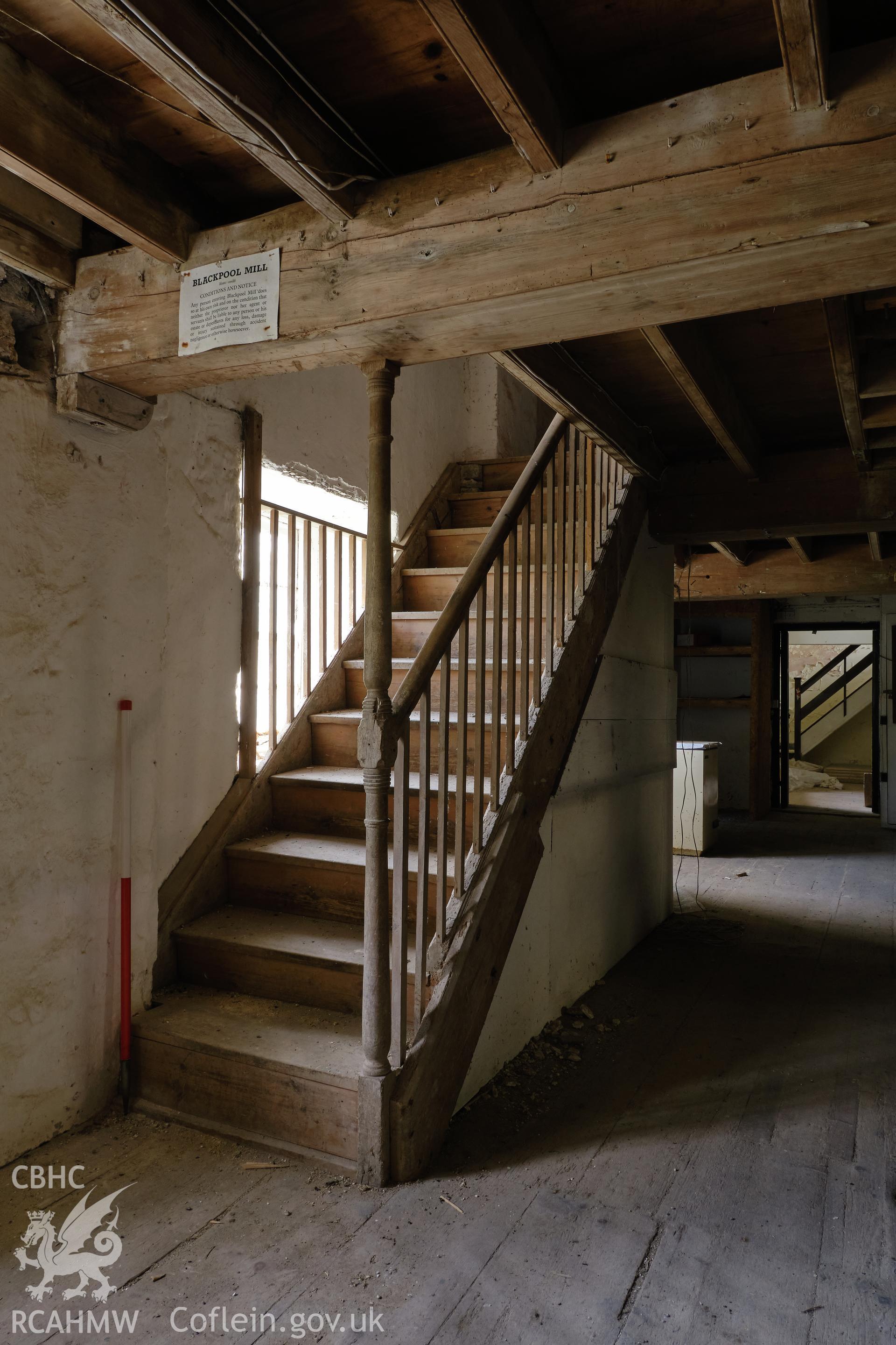 Colour photograph showing Blackpool Mill - ground floor, stair to 2nd floor, looking NE. Produced as part of Historic Building Recording for Blackpool Mill, carried out by Richard Hayman, June 2021.