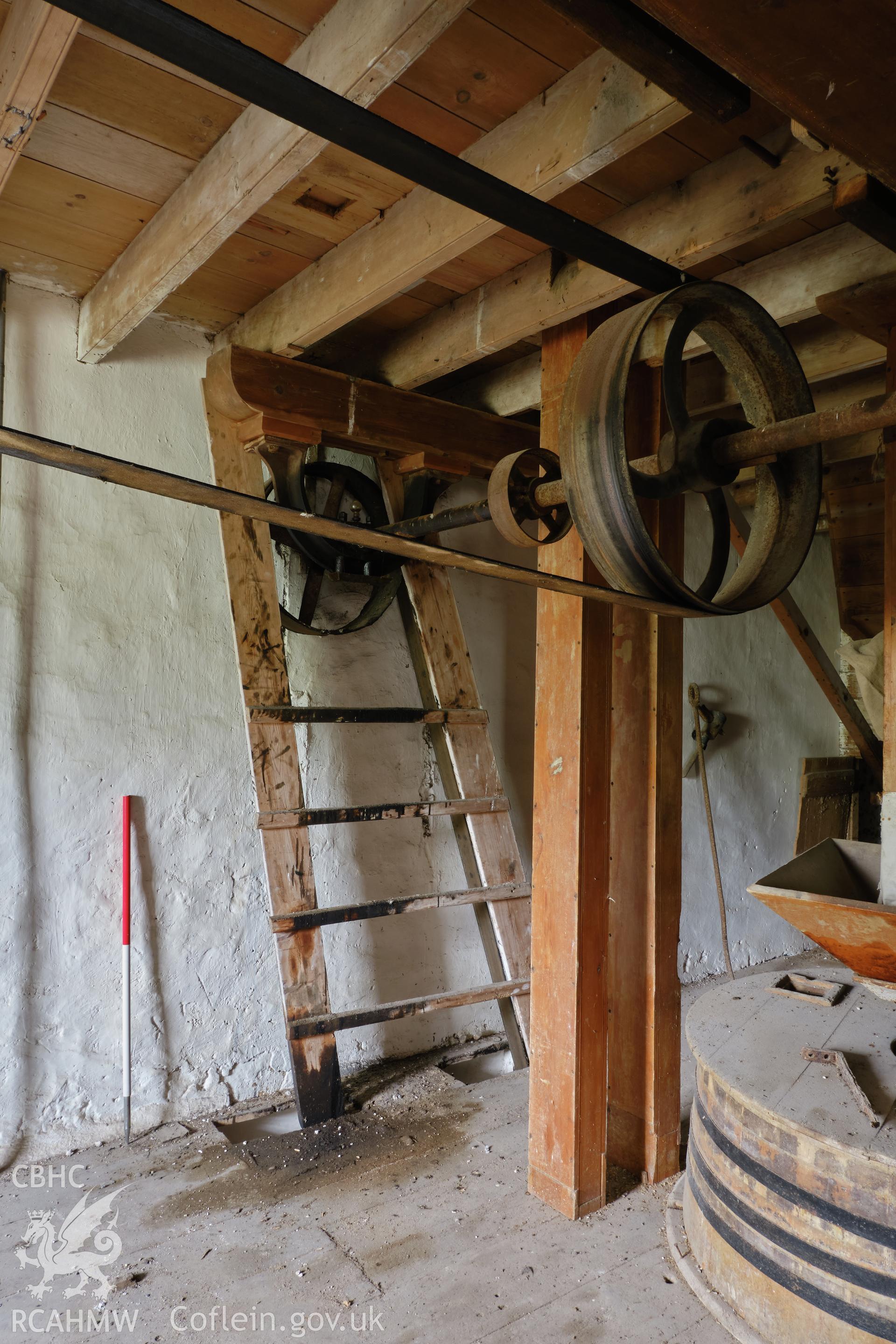 Colour photograph showing Blackpool Mill - 1st floor,  NE end of line shaft, with belt from electric motor, looking E. Produced as part of Historic Building Recording for Blackpool Mill, carried out by Richard Hayman, June 2021.