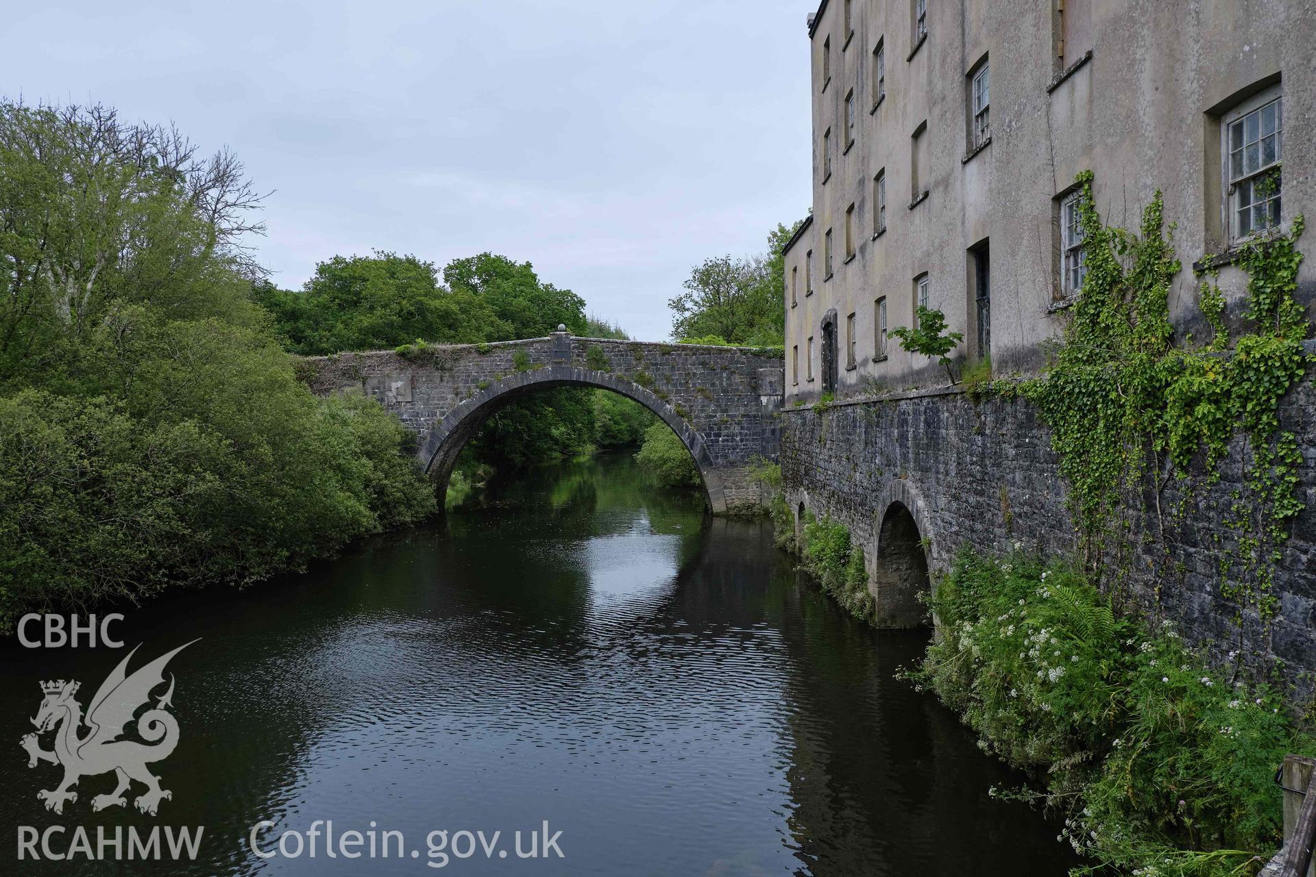 Colour photograph showing Blackpool Mill - NW wall with Slebech bridge & E Cleddau, looking NE. Produced as part of Historic Building Recording for Blackpool Mill, carried out by Richard Hayman, June 2021.