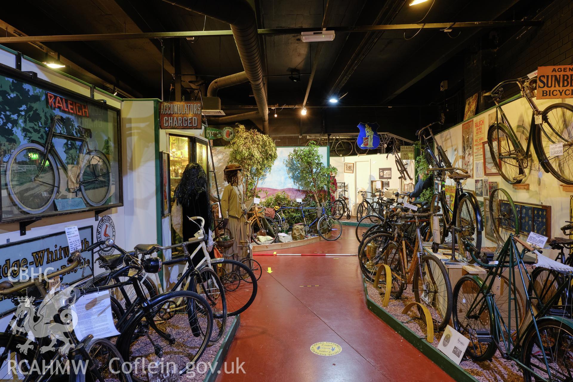 Colour photograph showing Automobile Palace - room G.9, looking SE. and National Cycle Collection exhibits. Produced as part of Historic Building Recording for Automobile Palace, carried out by Richard Hayman, June 2021.