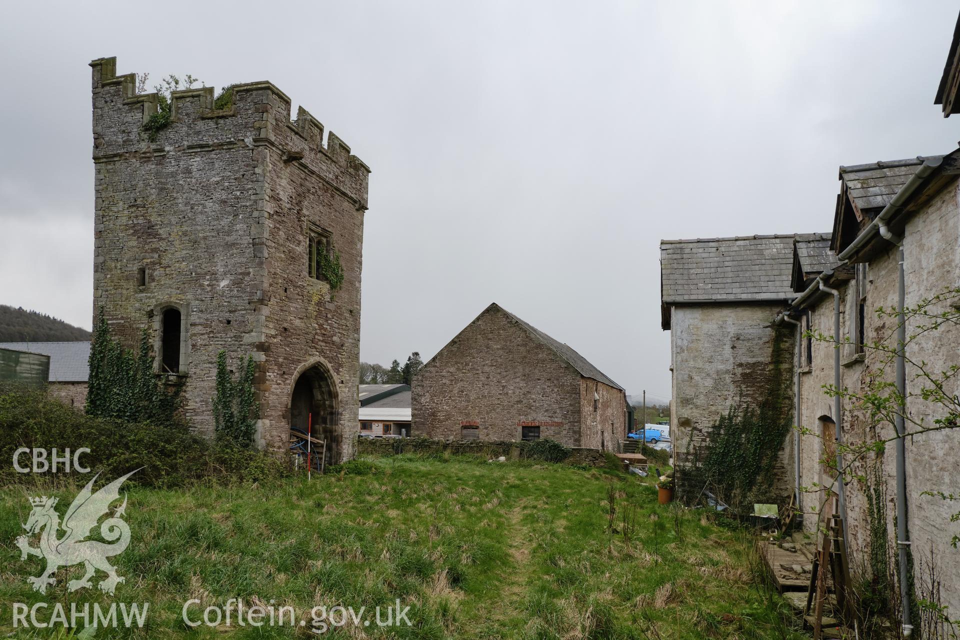 Colour photograph showing Great Porthmel Gatehouse - from farmhouse garden, looking S with farmhouse and farm building. Produced as part of Historic Building Recording for Great Porthamel Gatehouse, carried out by Richard Hayman, April 2021.