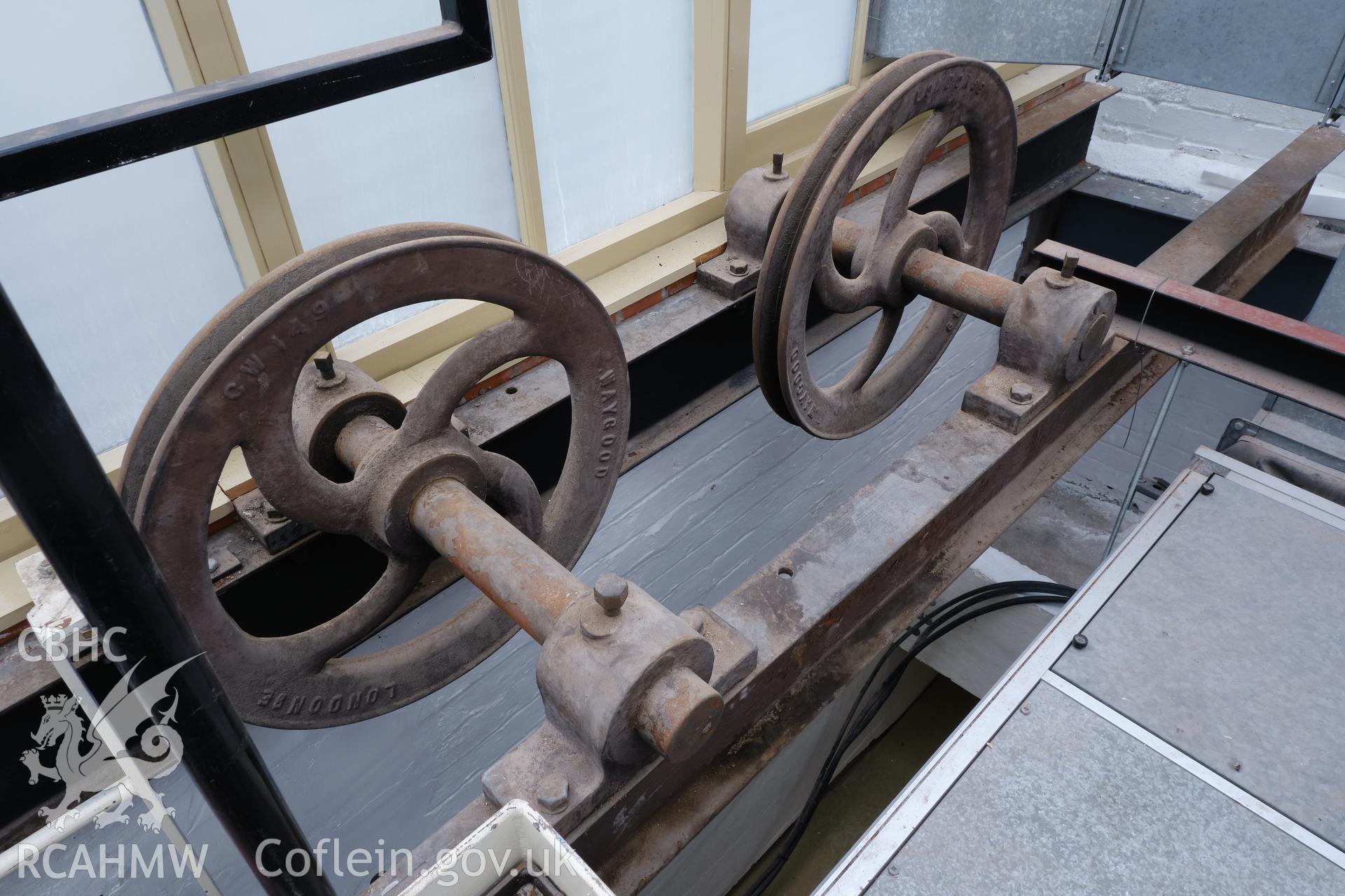 Colour photograph showing Automobile Palace - room 2.1, hoist pulley wheels, looking SE. Produced as part of Historic Building Recording for Automobile Palace, carried out by Richard Hayman, June 2021.