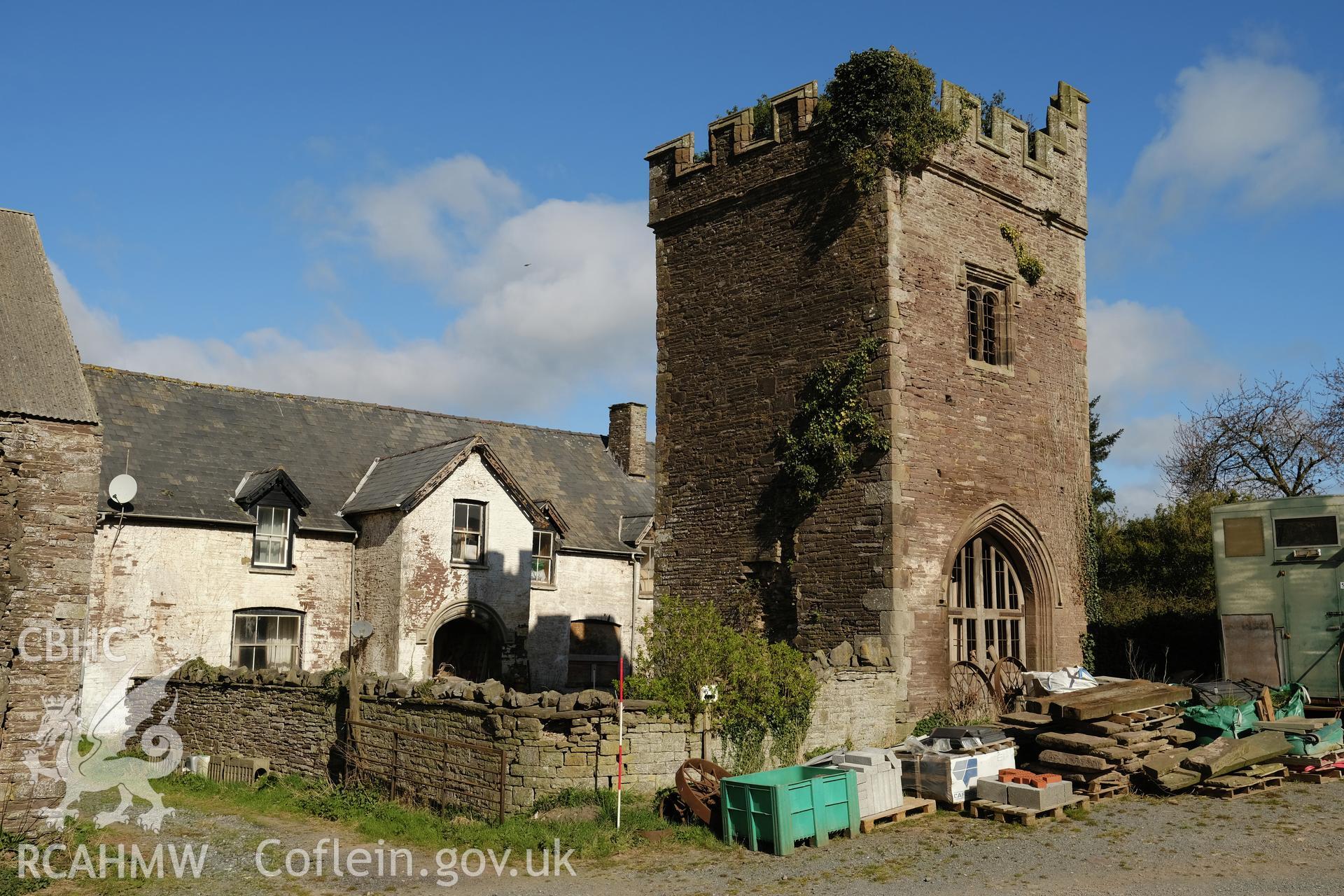 Colour photograph showing Great Porthmel Gatehouse - with farmhouse and garden wall, on S side of gatehouse, looking NW. Produced as part of Historic Building Recording for Great Porthamel Gatehouse, carried out by Richard Hayman, April 2021.