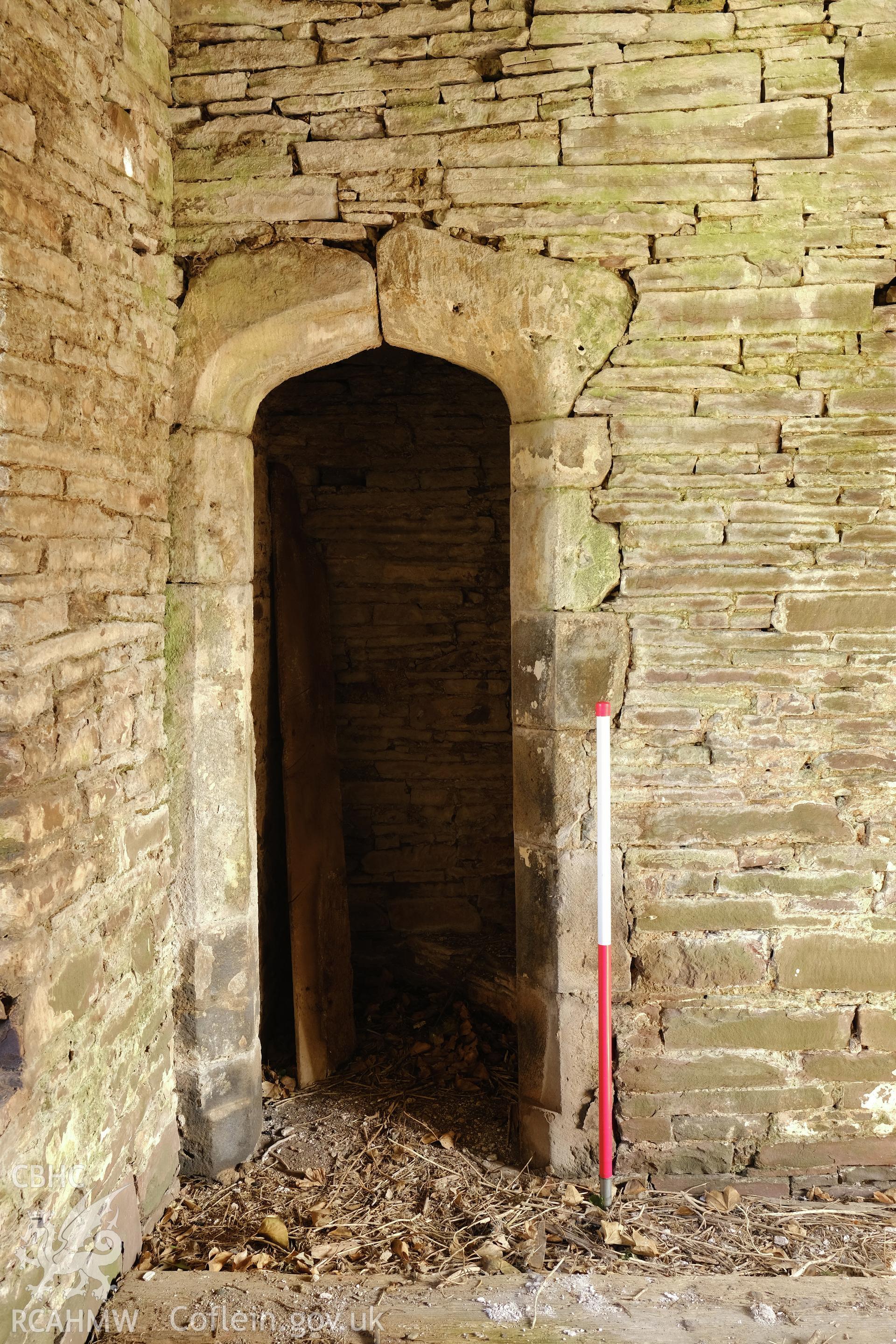 Colour photograph showing Great Porthmel Gatehouse - upper stage, doorway to parapet stair, looking NW. Produced as part of Historic Building Recording for Great Porthamel Gatehouse, carried out by Richard Hayman, April 2021.