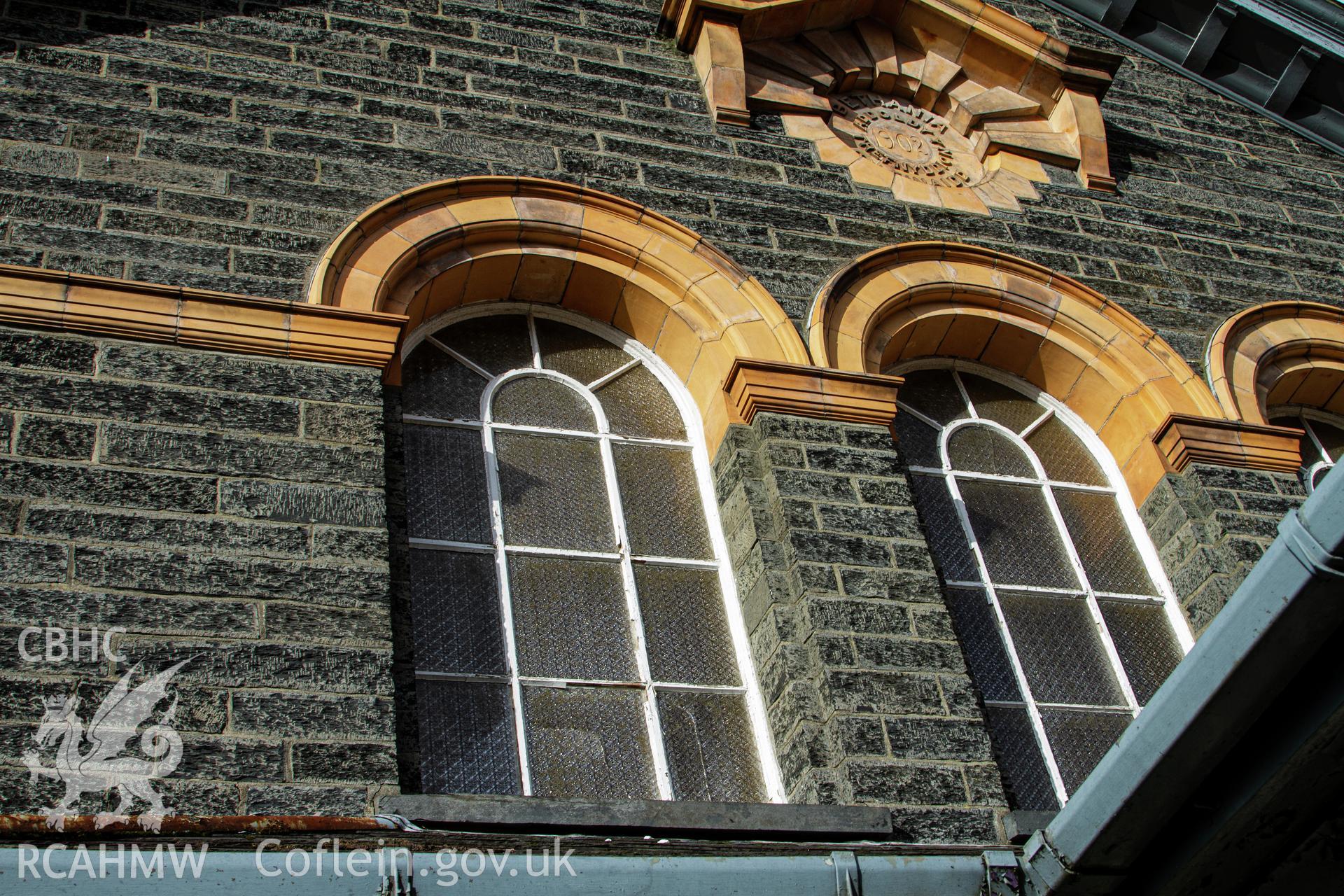 Colour photograph of close up view of main front windows and date stone brickwork - part of a photographic survey of Bethania Chapel, Aberangell, Gwynedd, produced for John Linden by Adrian John Hexter as a condition of planning consent. (Planning Application Ref. No. NP5/74/L319). Snowdonia National Park Planning Authority.