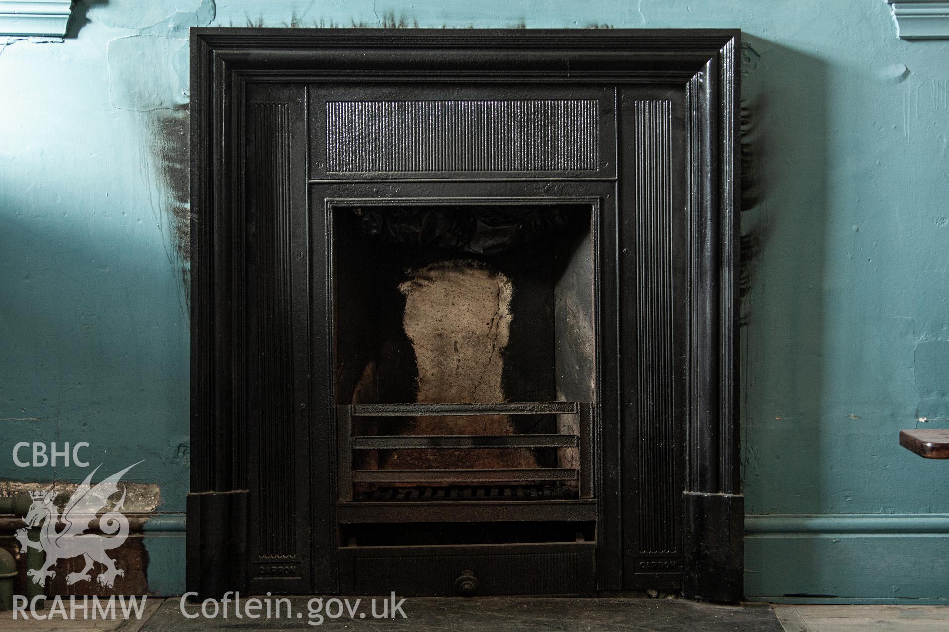 Colour photograph of one of two identical fireplaces in vestry, cast iron, slate hearth - part of a photographic survey of Bethania Chapel, Aberangell, Gwynedd, produced for John Linden by Adrian John Hexter as a condition of planning consent. (Planning Application Ref. No. NP5/74/L319). Snowdonia National Park Planning Authority.