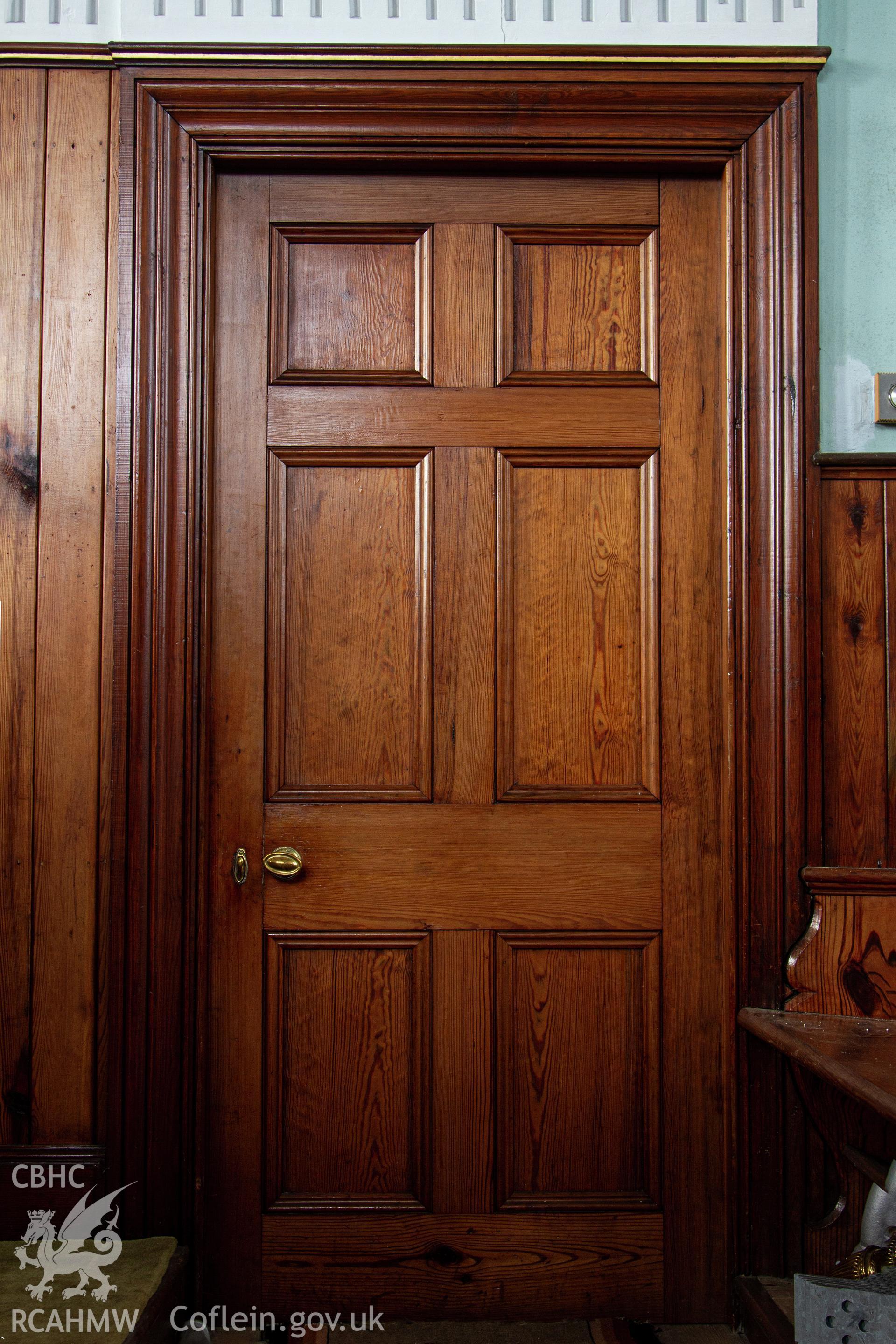 Colour photograph of solid pitch pine panelled door from chapel to vestry - part of a photographic survey of Bethania Chapel, Aberangell, Gwynedd, produced for John Linden by Adrian John Hexter as a condition of planning consent. (Planning Application Ref. No. NP5/74/L319). Snowdonia National Park Planning Authority.