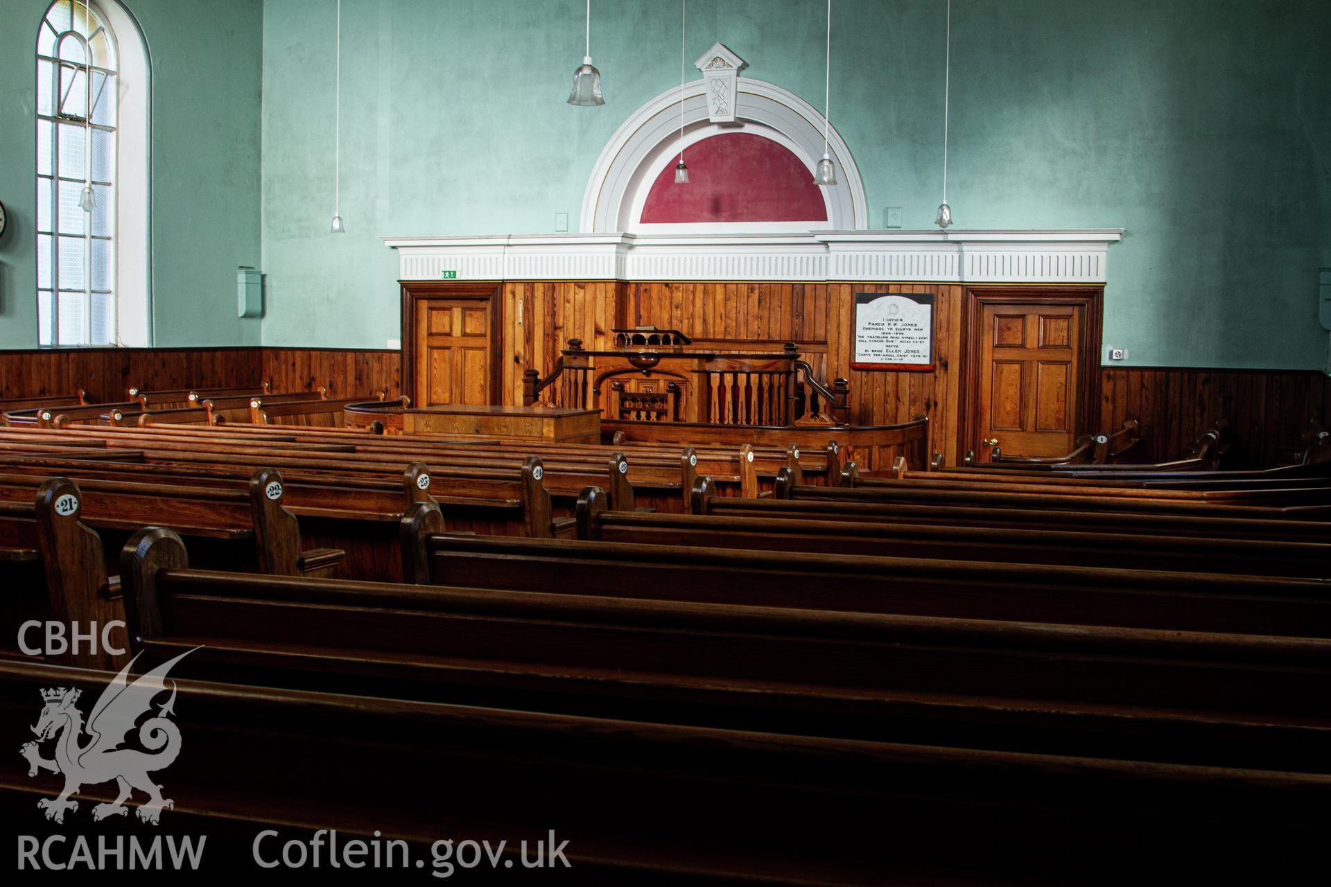 Colour photograph of interior - pews looking to front of chapel - part of a photographic survey of Bethania Chapel, Aberangell, Gwynedd, produced for John Linden by Adrian John Hexter, as a condition of planning consent. (Planning Application Ref. No. NP5/74/L319). Snowdonia National Park Planning Authority.