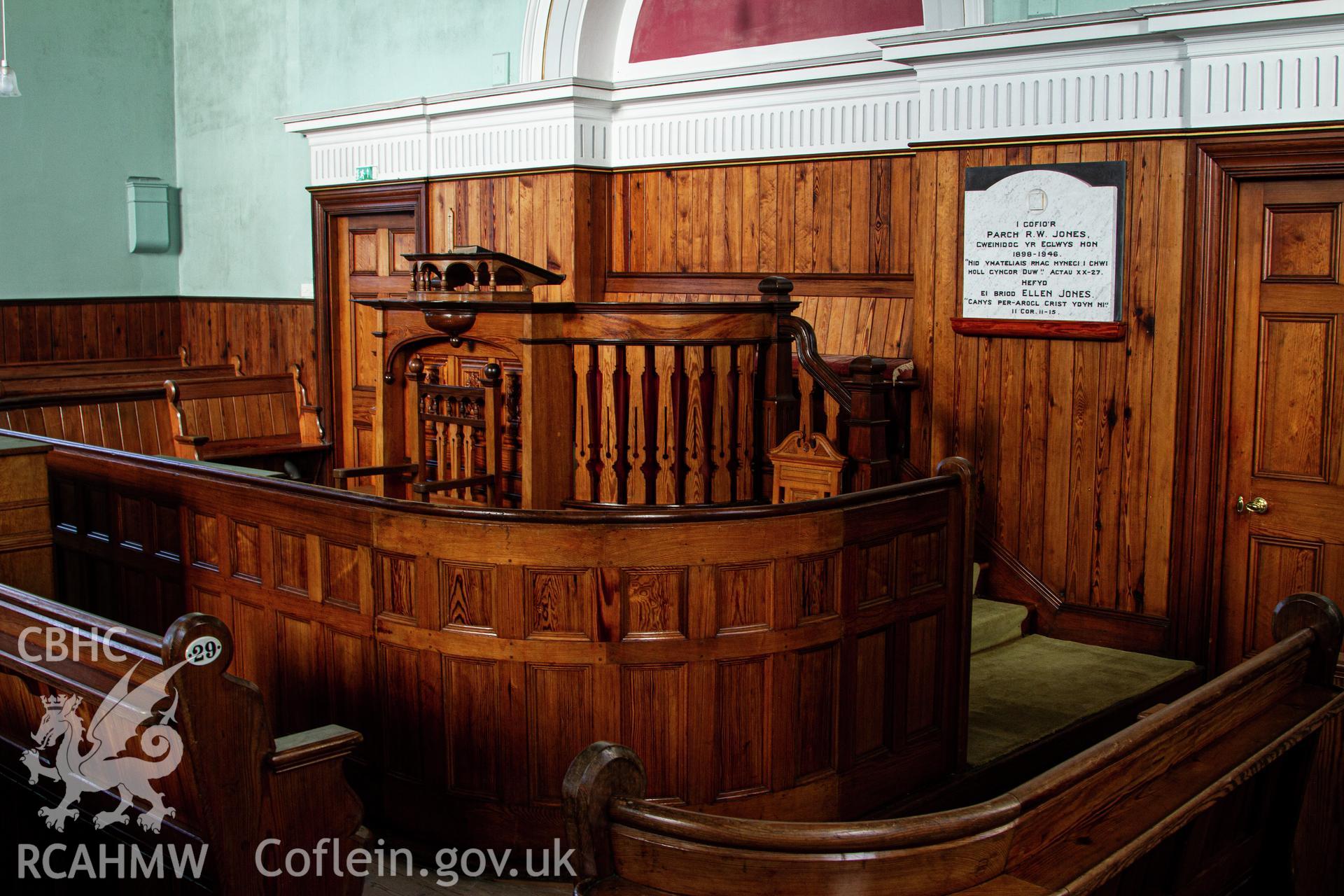 Colour photograph of interior - pitch pine pulpit and back of curved elders pew - part of a photographic survey of Bethania Chapel, Aberangell, Gwynedd, produced for John Linden by Adrian John Hexter, as a condition of planning consent. (Planning Application Ref. No. NP5/74/L319). Snowdonia National Park Planning Authority.