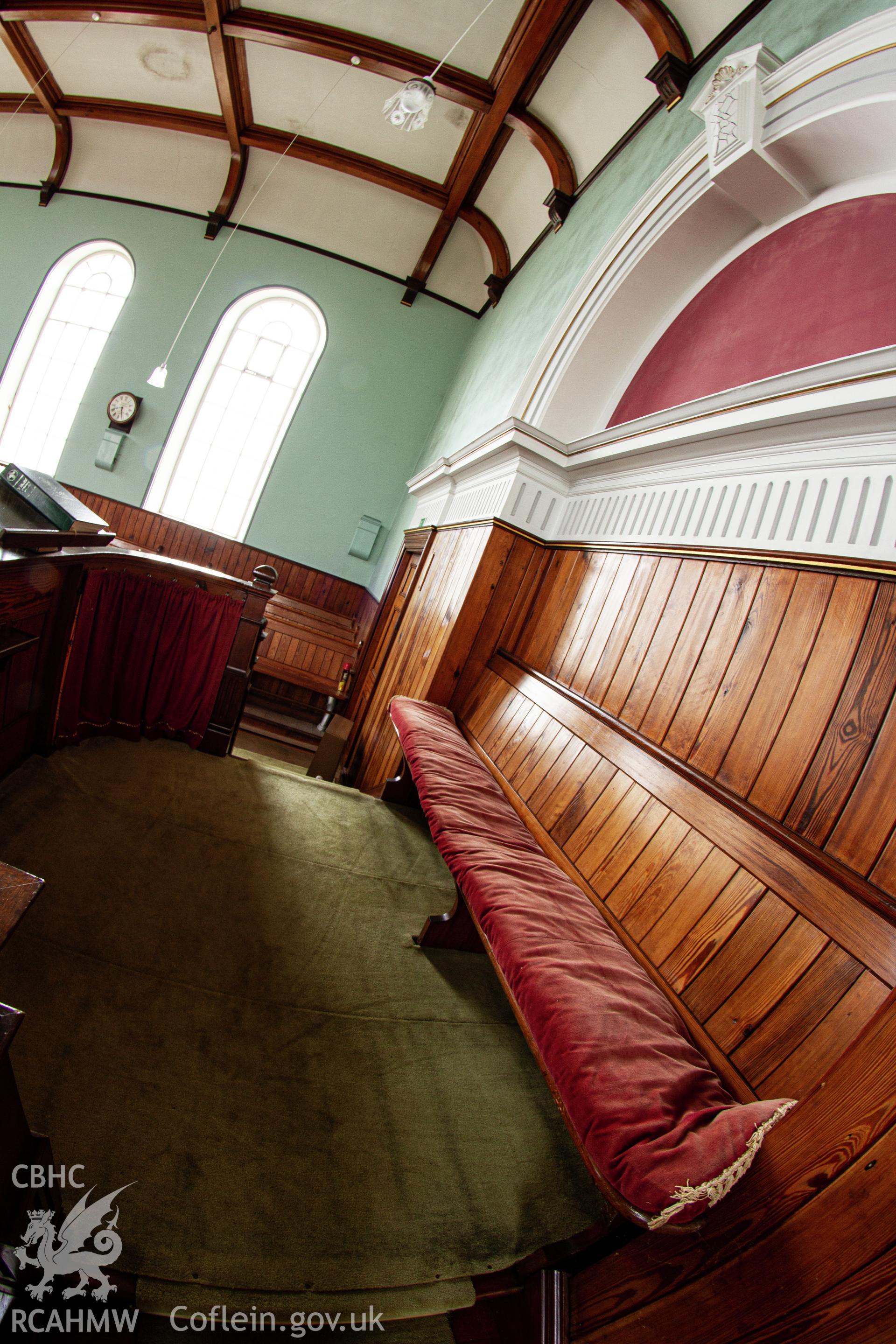 Colour photograph of interior - pew and wood panelling behind pulpit - part of a photographic survey of Bethania Chapel, Aberangell, Gwynedd, produced for John Linden by Adrian John Hexter, as a condition of planning consent. (Planning Application Ref. No. NP5/74/L319). Snowdonia National Park Planning Authority.