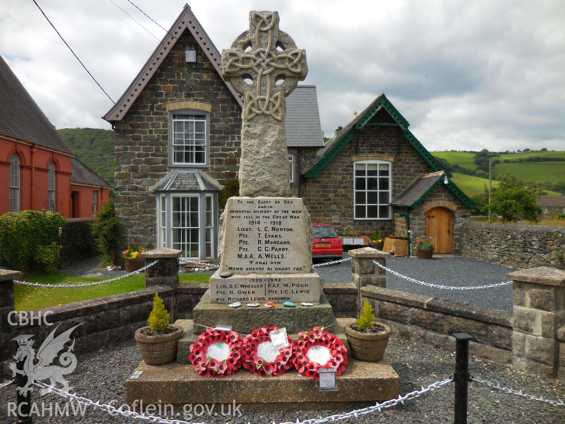 Colour digital photograph showing Cemmaes war memorial, with poppy wreaths, taken in November 2021.