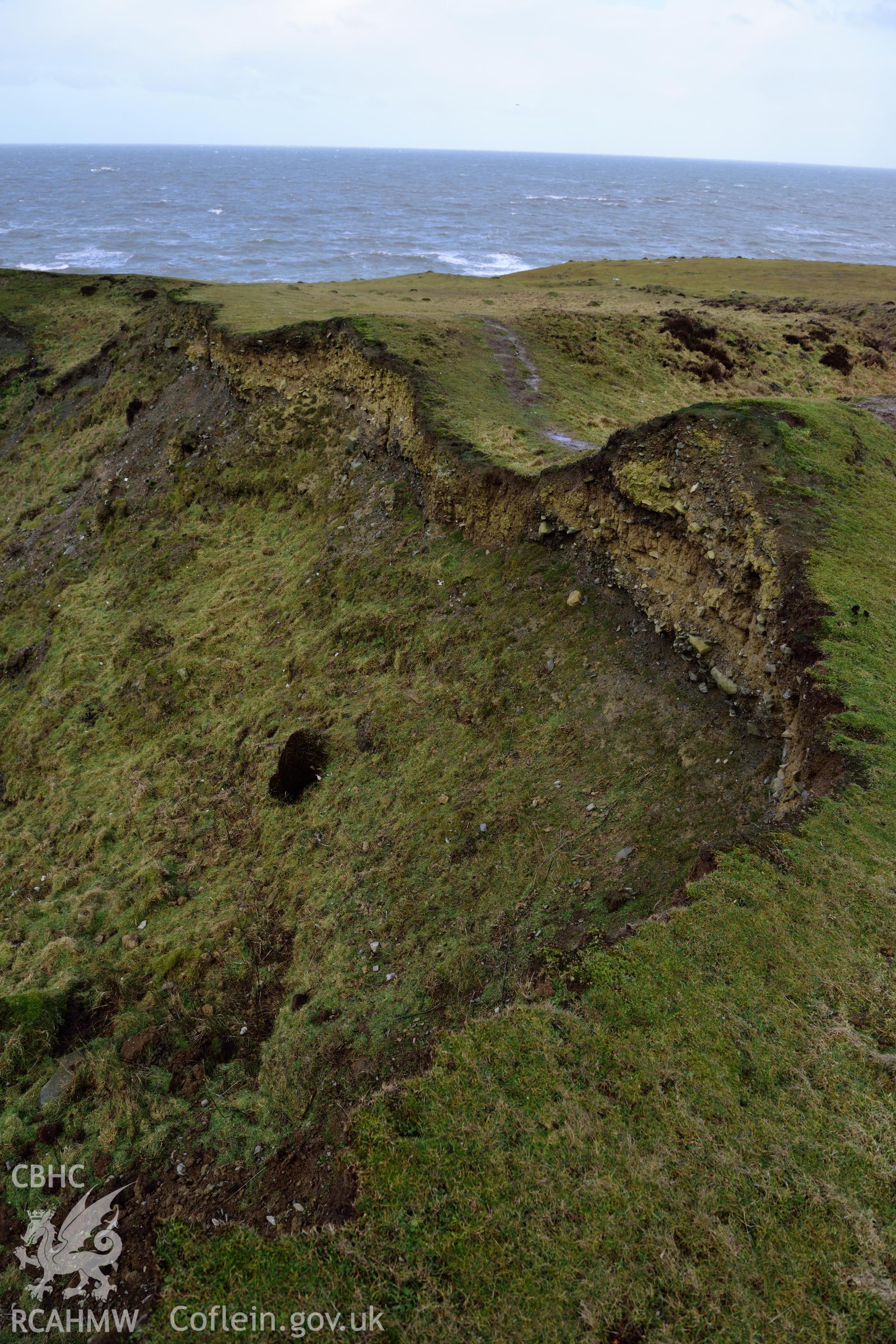 Eroding section edge of Castell Bach promontory fort (NPRN 93914)  Camera facing NNE. Taken by Daniel Hunt for site monitoring 13/02/2018.
Produced with EU funds through the Ireland Wales Co-operation Programme 2014-2020. All material made freely available through the Open Government Licence.