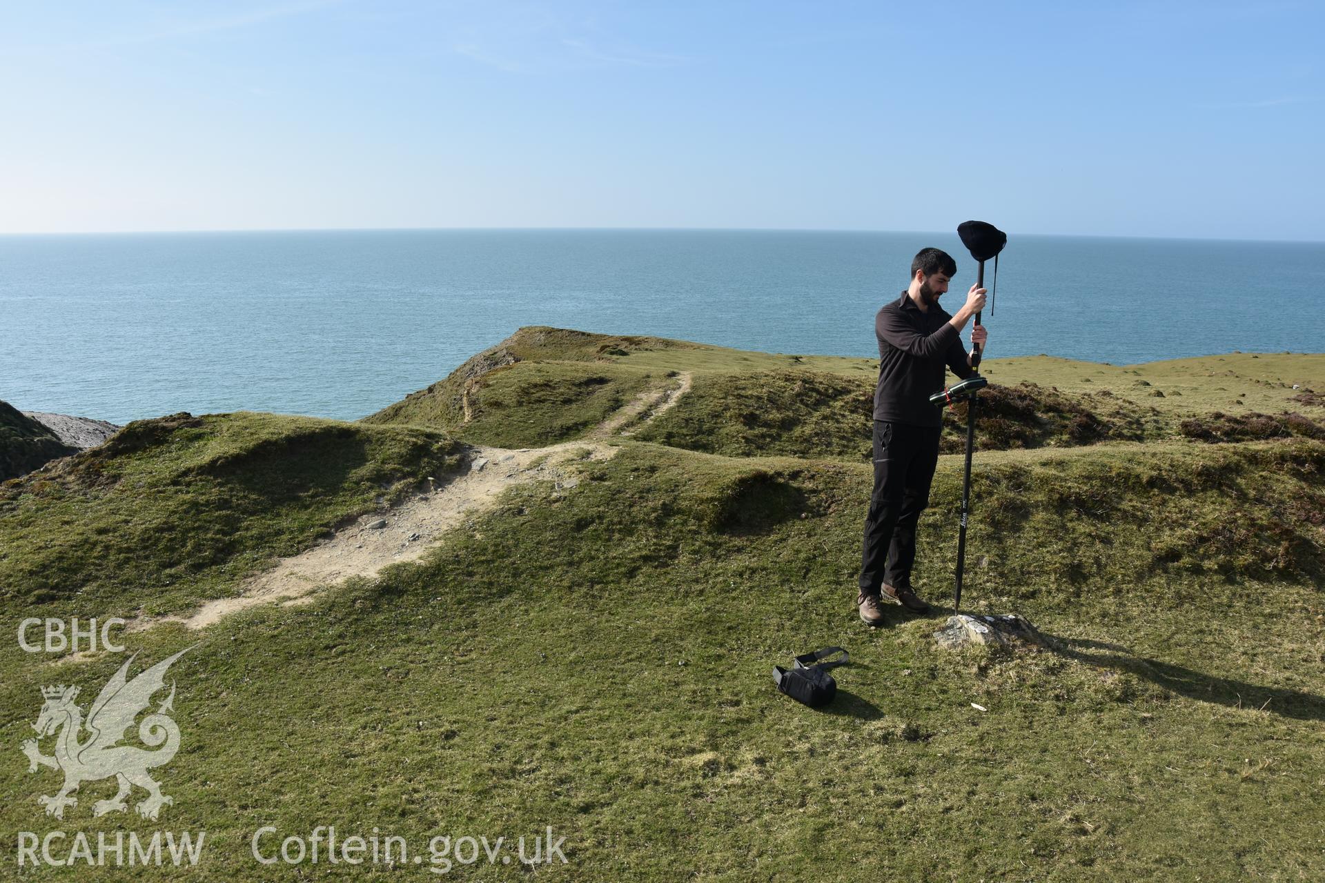 CHERISH project team measuring location of survey marker. Camera facing N. From photographic survey of Castell Bach (NPRN 93914) by Dr Toby Driver for site monitoring 27/03/2019.
Produced with EU funds through the Ireland Wales Co-operation Programme 2014-2020. All material made freely available through the Open Government Licence.