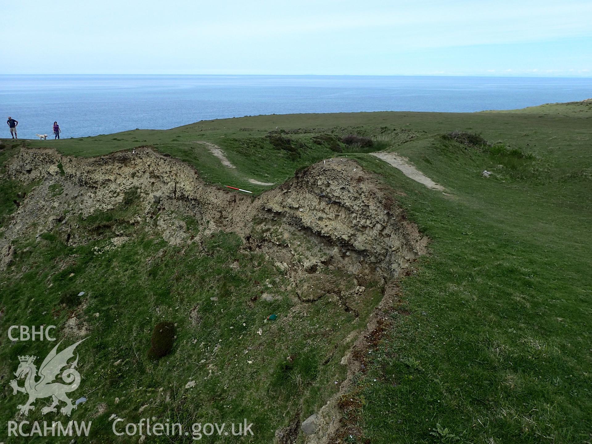Eroding section photographed from above, showing ramparts and ditch. From photographic survey of Castell Bach promontory fort (NPRN 93914) by Daniel Hunt for CHERISH project condition monitoring 27/05/2021.
Produced with EU funds through the Ireland Wales Co-operation Programme 2014-2020. All material made freely available through the Open Government Licence.