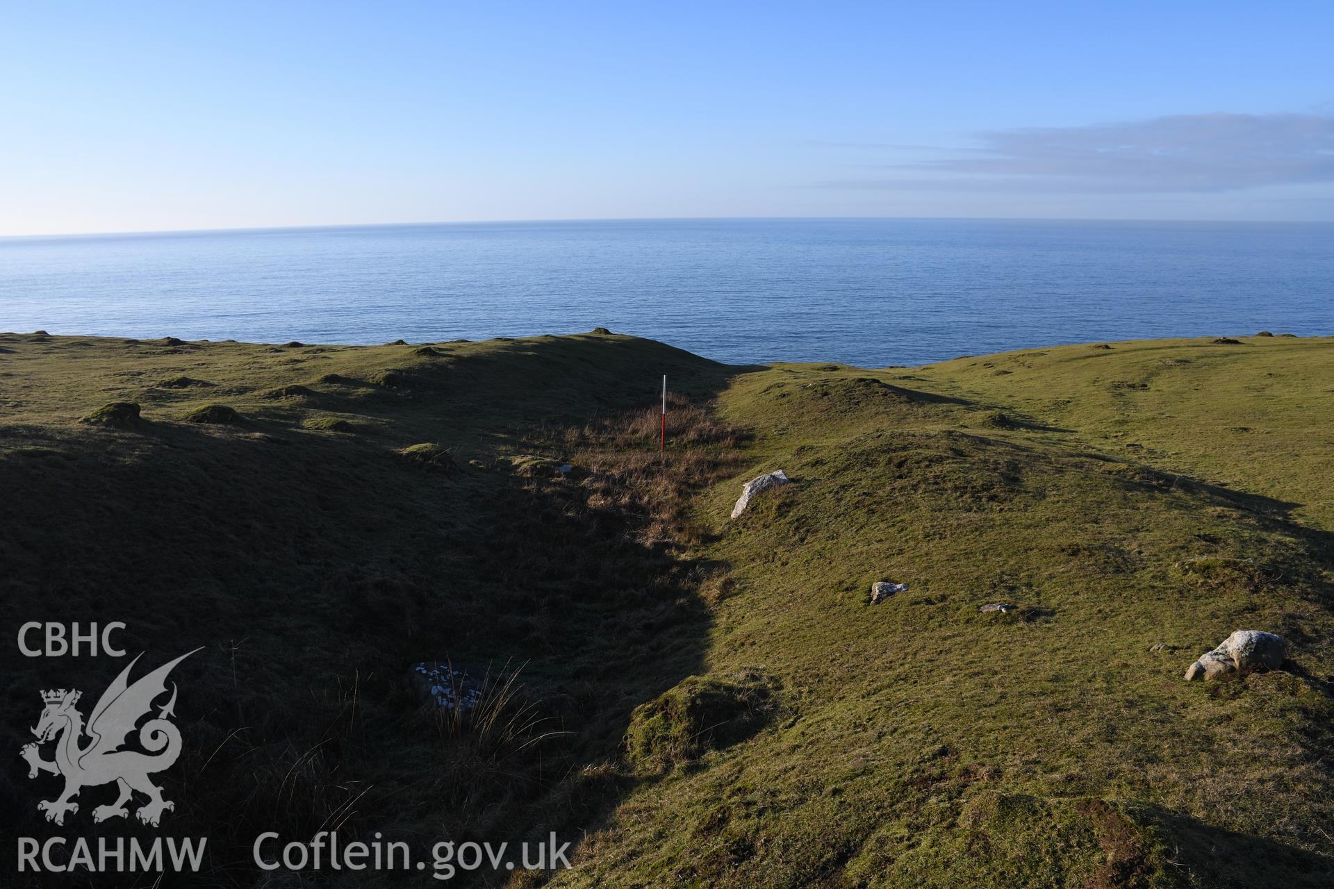 N end of inner ramparts showing gate, with 1m scale, camera facing N. Photographic survey of Castell Bach promontory fort (NPRN 93914) using 1m scales and human figures. Undertaken by Hannah Genders Boyd for CHERISH project condition monitoring 13/01/2022.
Produced with EU funds through the Ireland Wales Co-operation Programme 2014-2020. All material made freely available through the Open Government Licence.