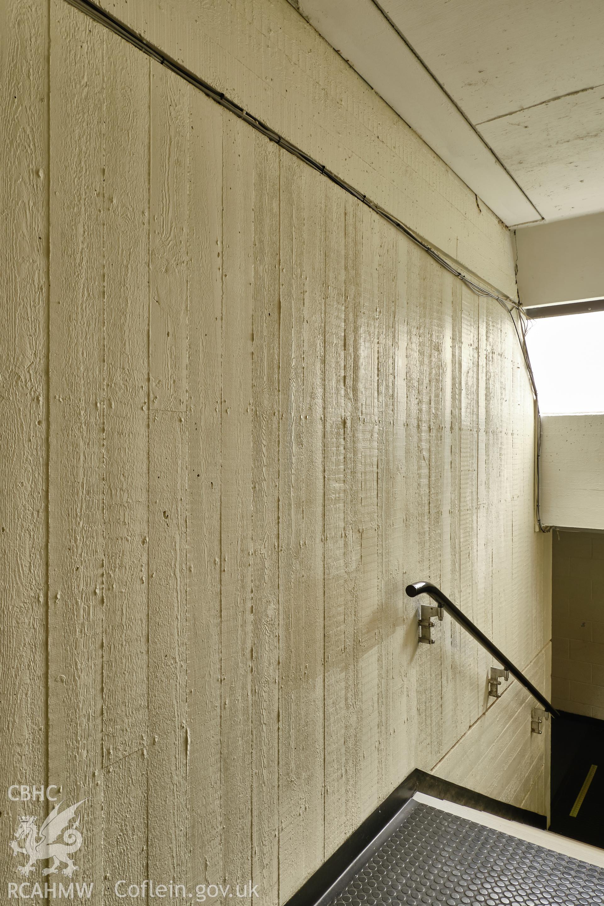 Colour photograph showing Argoed School - stair between staff room (1st floor) & science classrooms (ground floor), boardmarked concrete wall.