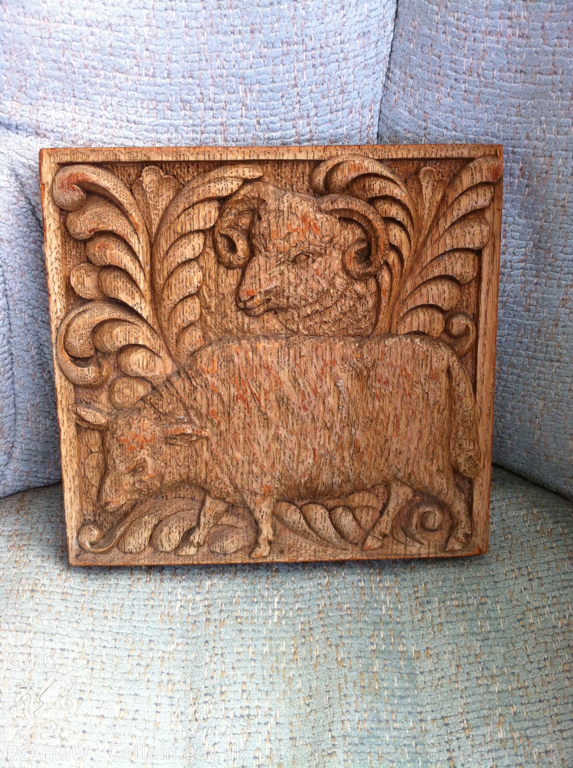 Digital photograph taken by Gillian Swan in 2017 showing wooden tile depicting two sheep. The tile is associated with Bryngwenallt Hall, Abergele.