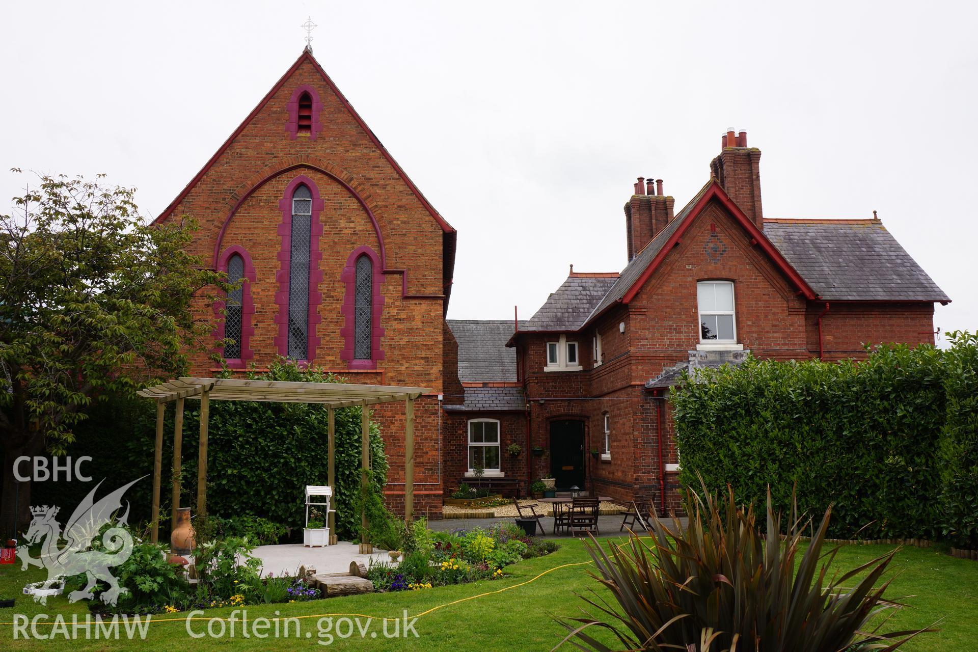 Digital colour photograph showing the presbytery, garden and exterior of Immaculate Conception Catholic church, Flint.