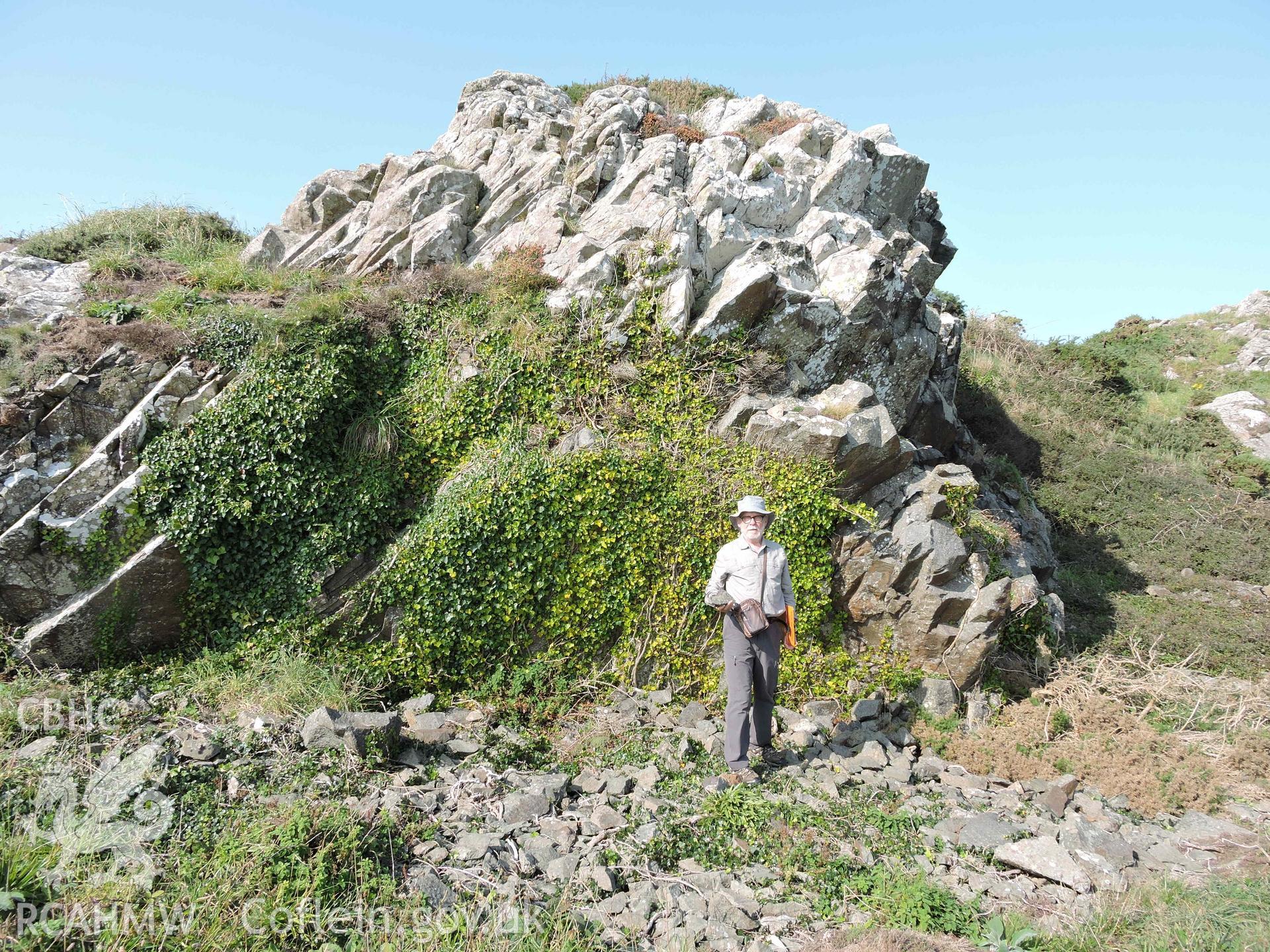 Figure standing at base of rock formation at Craig Cwlwm Quarry, Aberdaron. Part of a digital photographic survey produced in 2020 by Michael Statham.